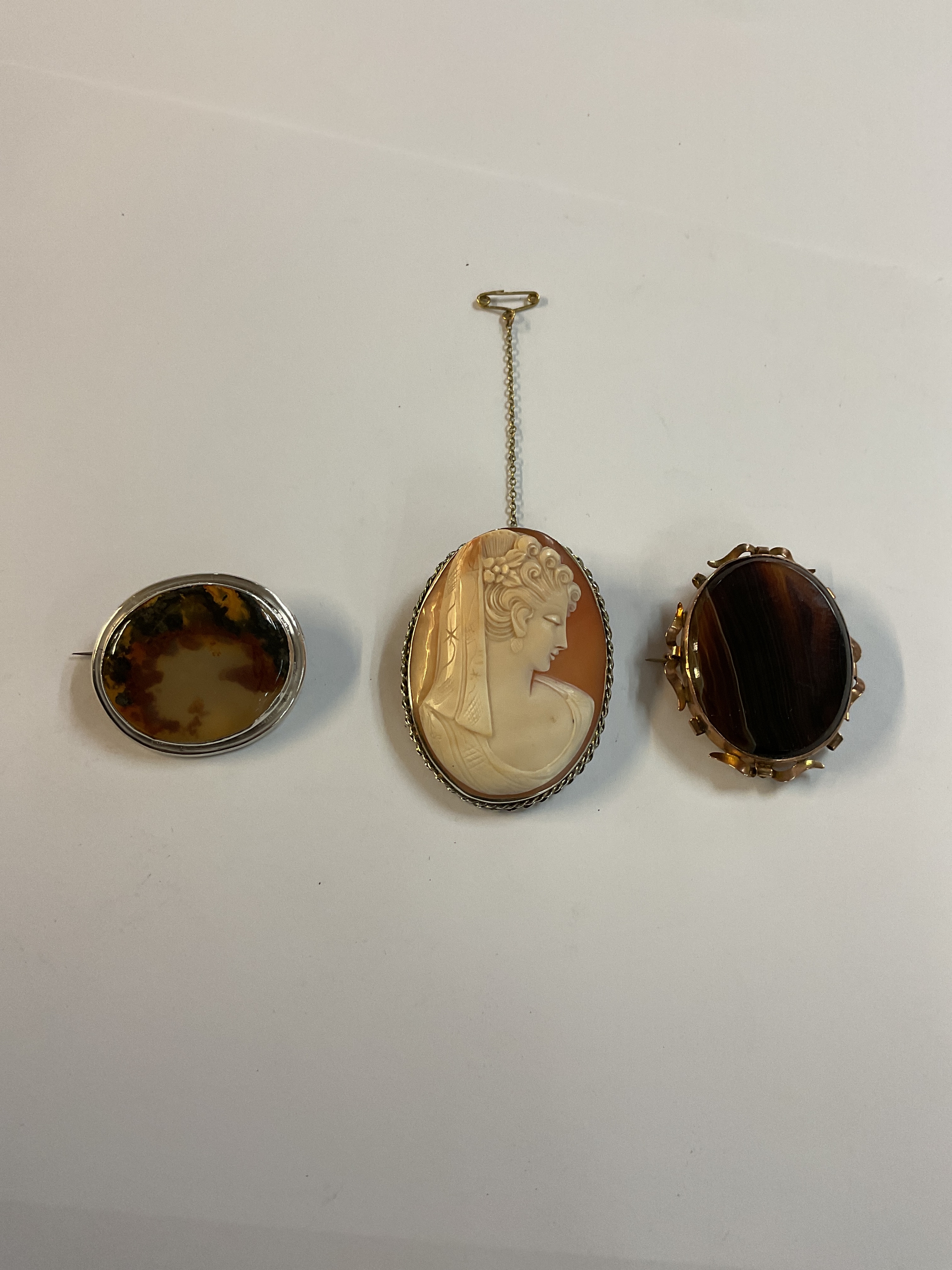 Three Brooches to inc a Cameo, a Smokey Quartz in a silver mount and a brown Agate.