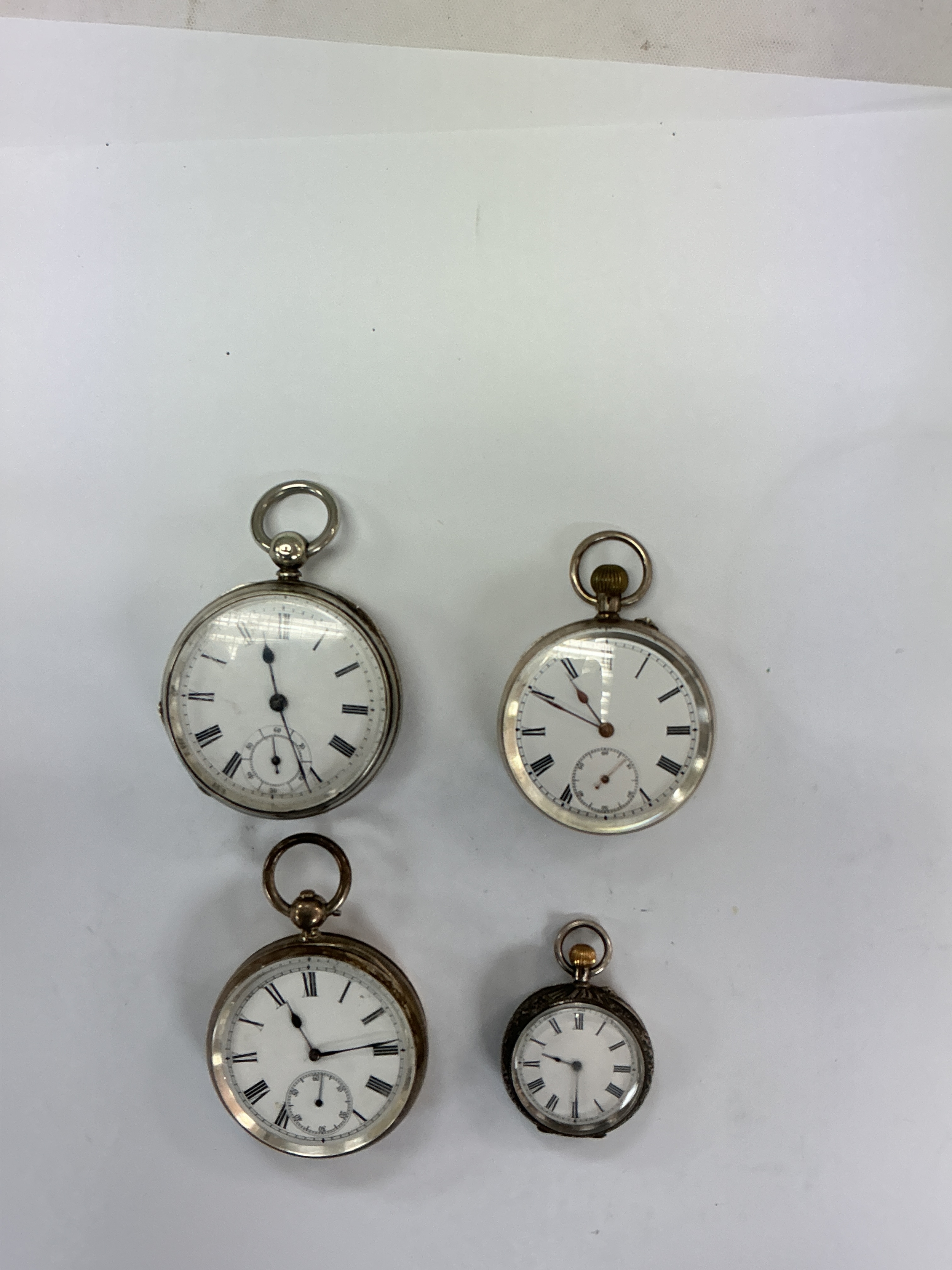 Three silver cased pocket watches, one having Swiss movement, plus a plated example.Approx 5-3cm wide.340g total weight