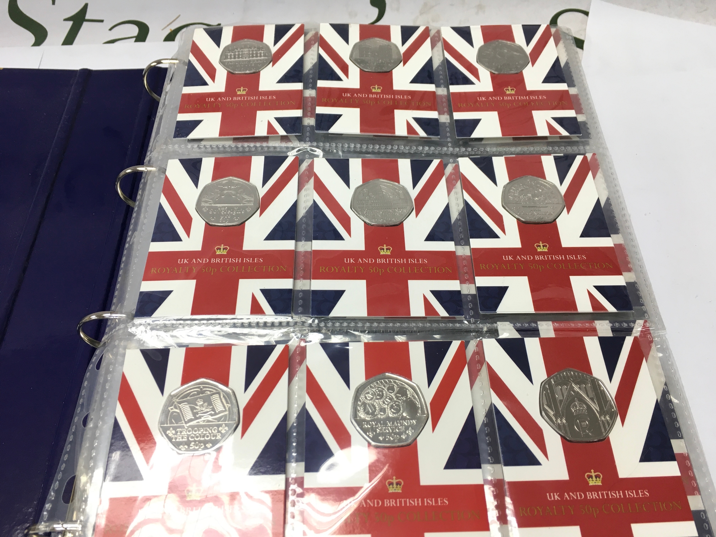 A change checker folder containing various commemorative 50p coins including star wars, christmas examples etc.