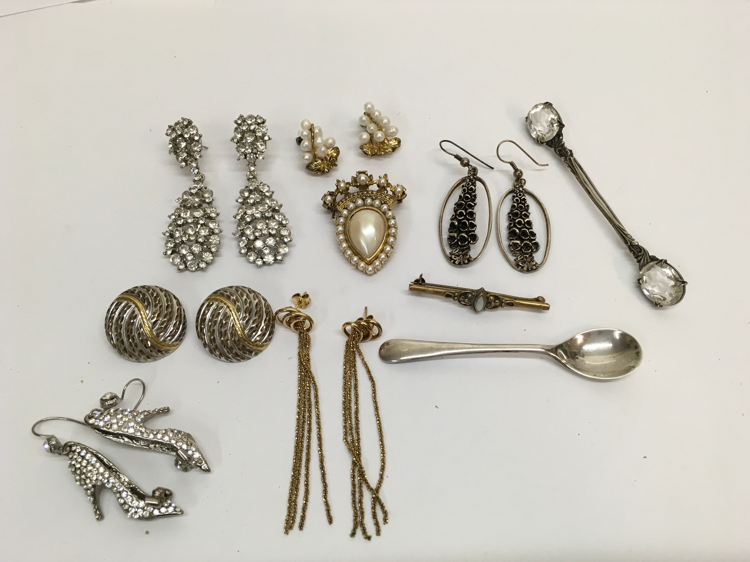 A small group of jewellery including a silver gilt and pearl brooch, a sterling silver and cut crystal example, a silver spoon and earrings