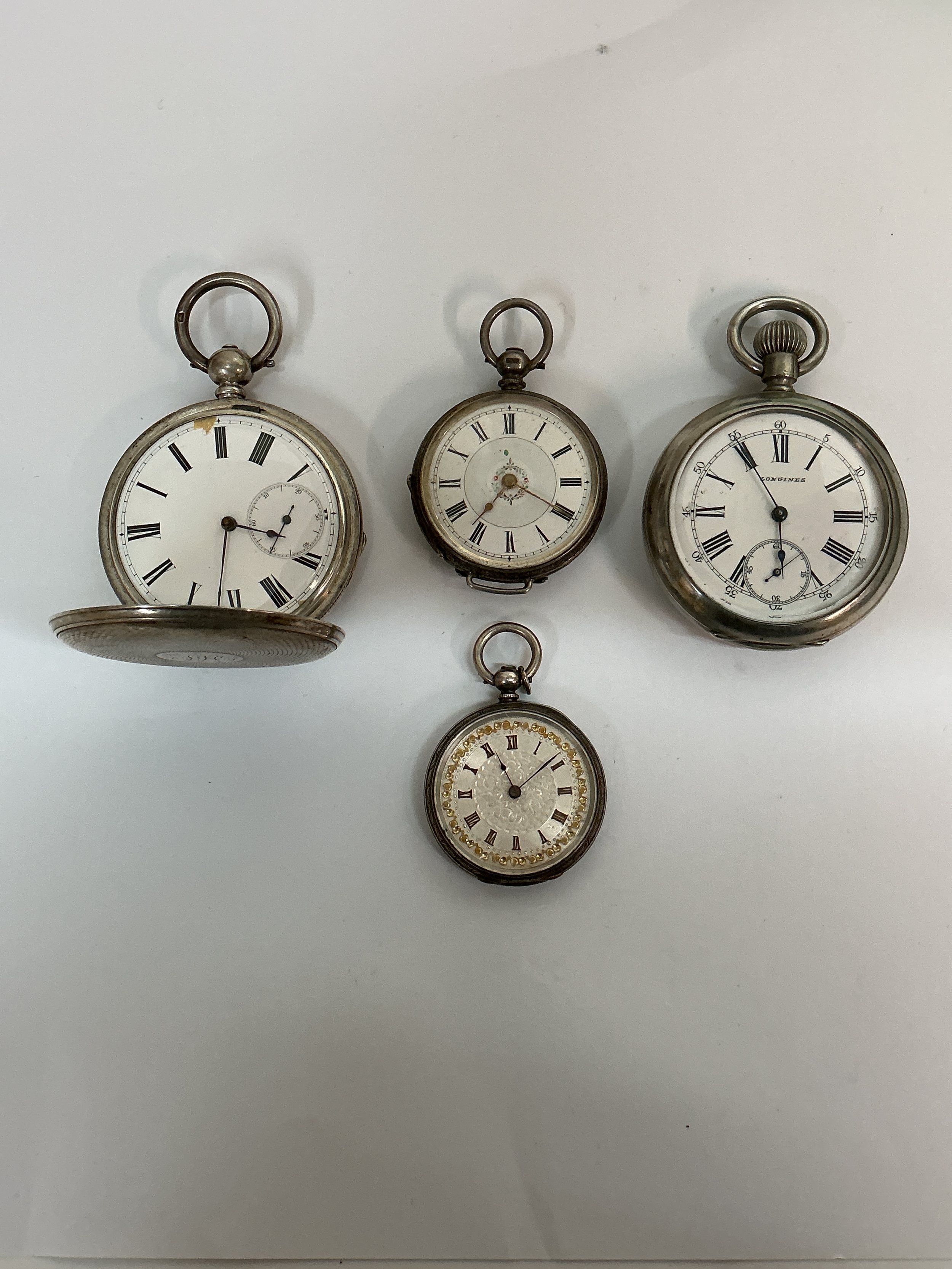 A Longines pocket watch plus three other silver cased examples. Approx 4.5 - 3.5cm. Offered for restoration 265g