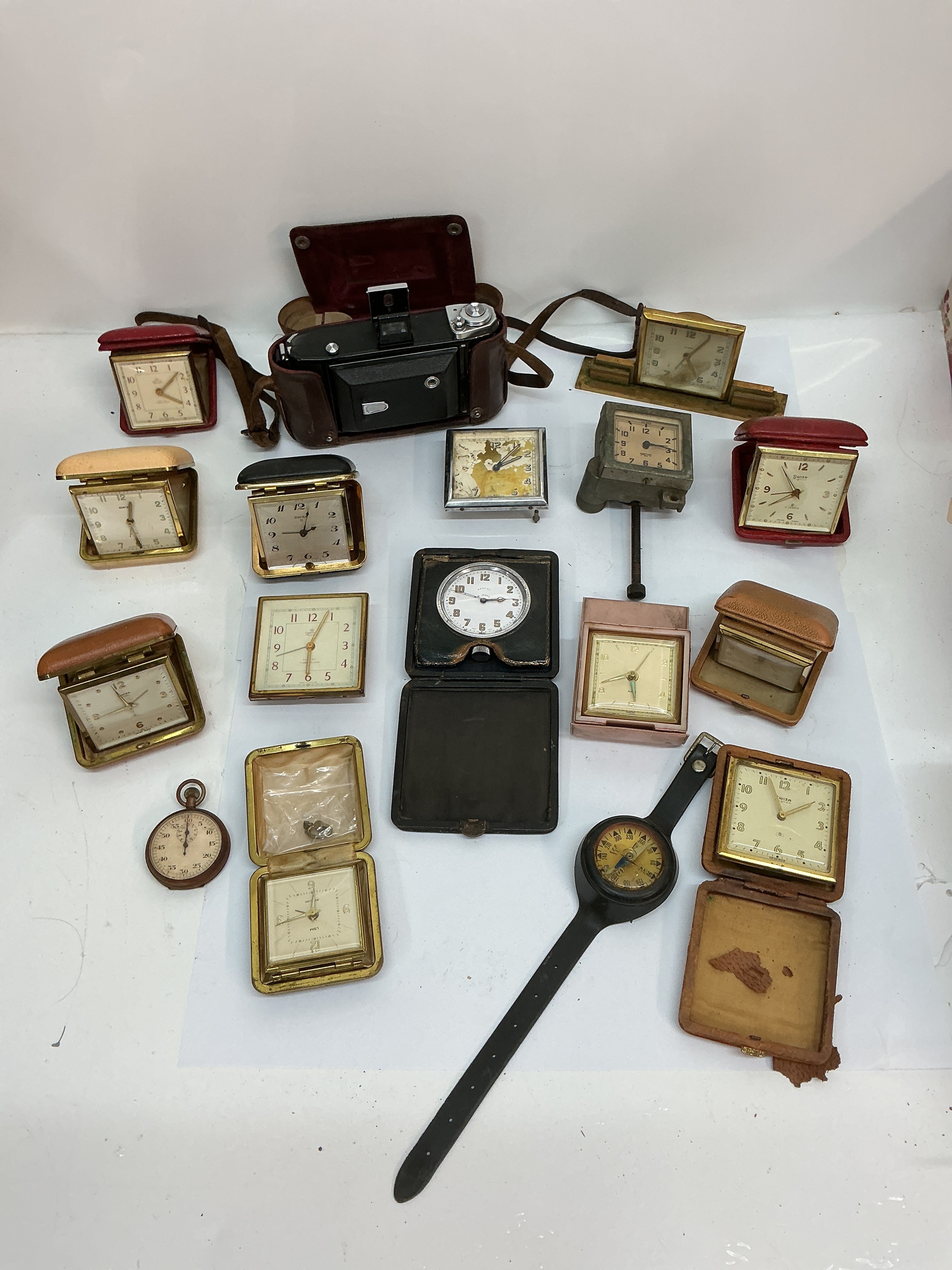 A collection of vintage travelling clocks including Swiza and Smiths, plus a Zeiss Icon camera. Offered for restoration.