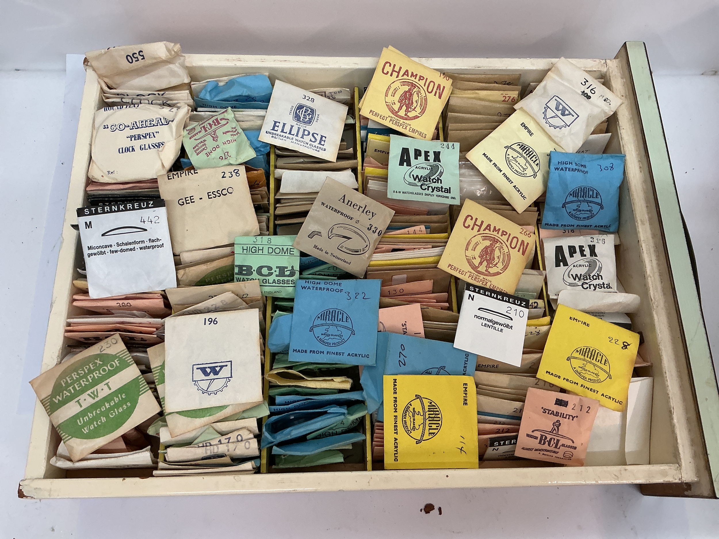 A tray containing vintage watch glasses