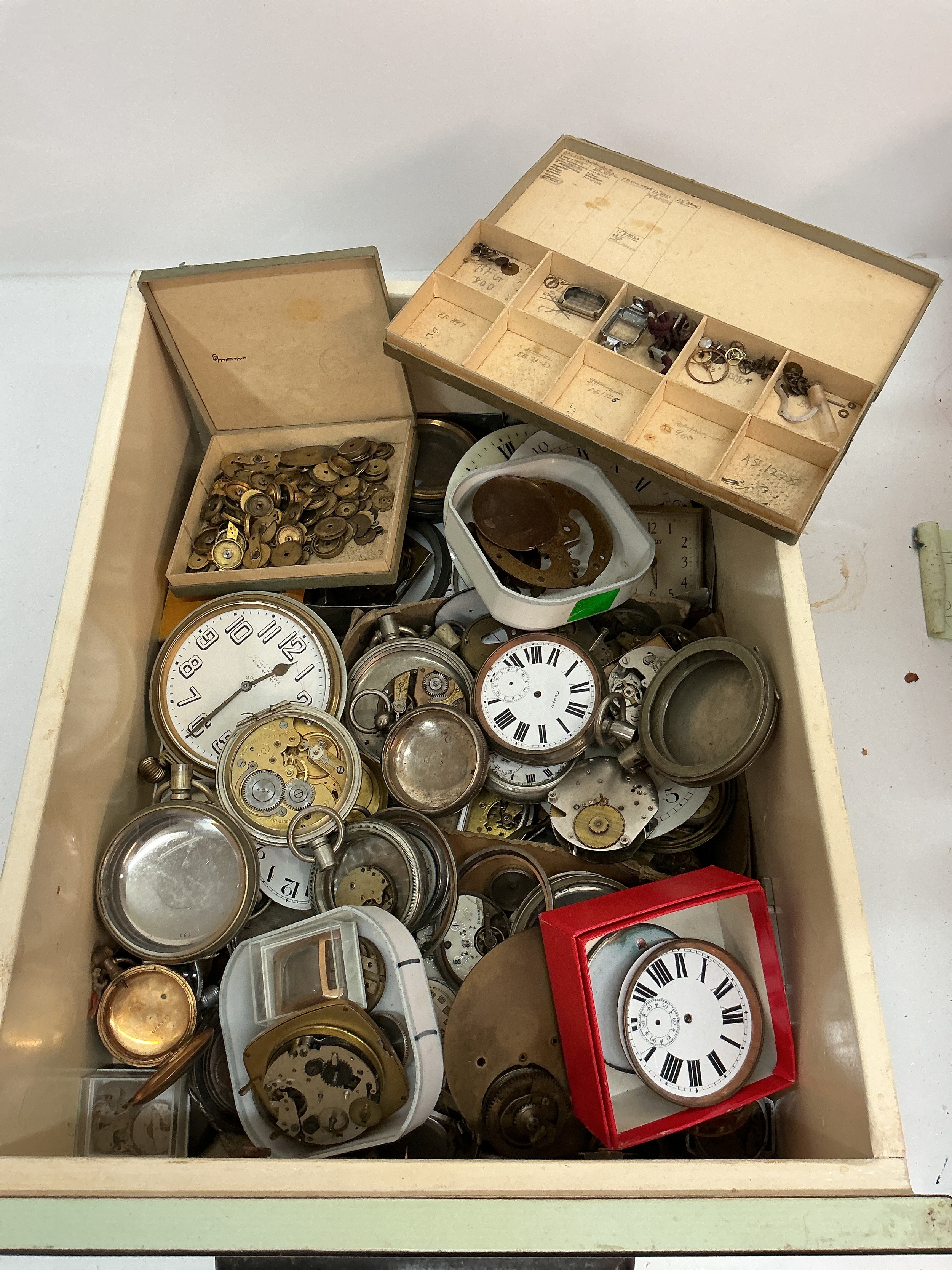 A tray of assorted vintage Goliath watch cases and parts. Offered for spares or repairs