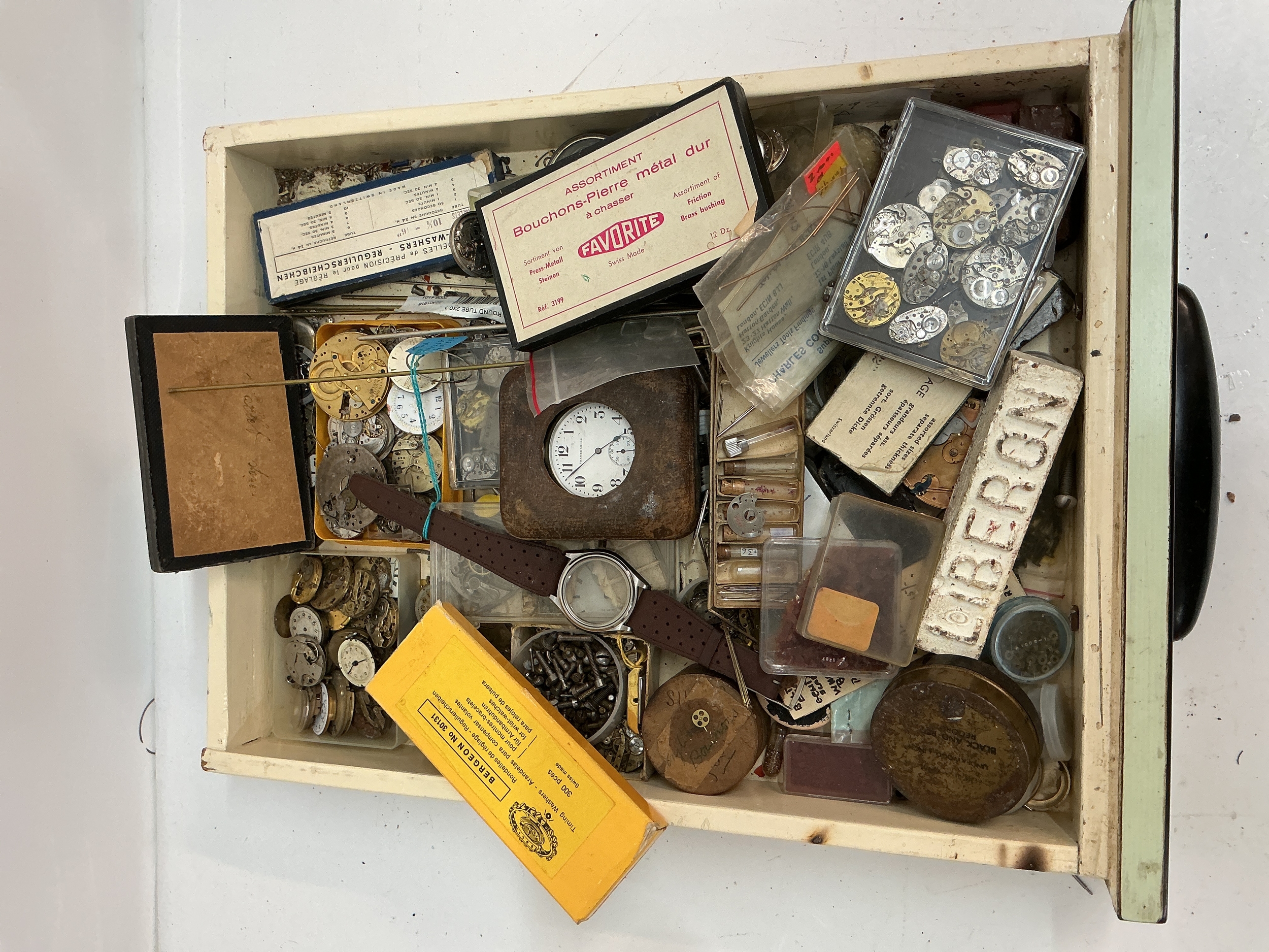 A tray containing assorted watch movers and parts