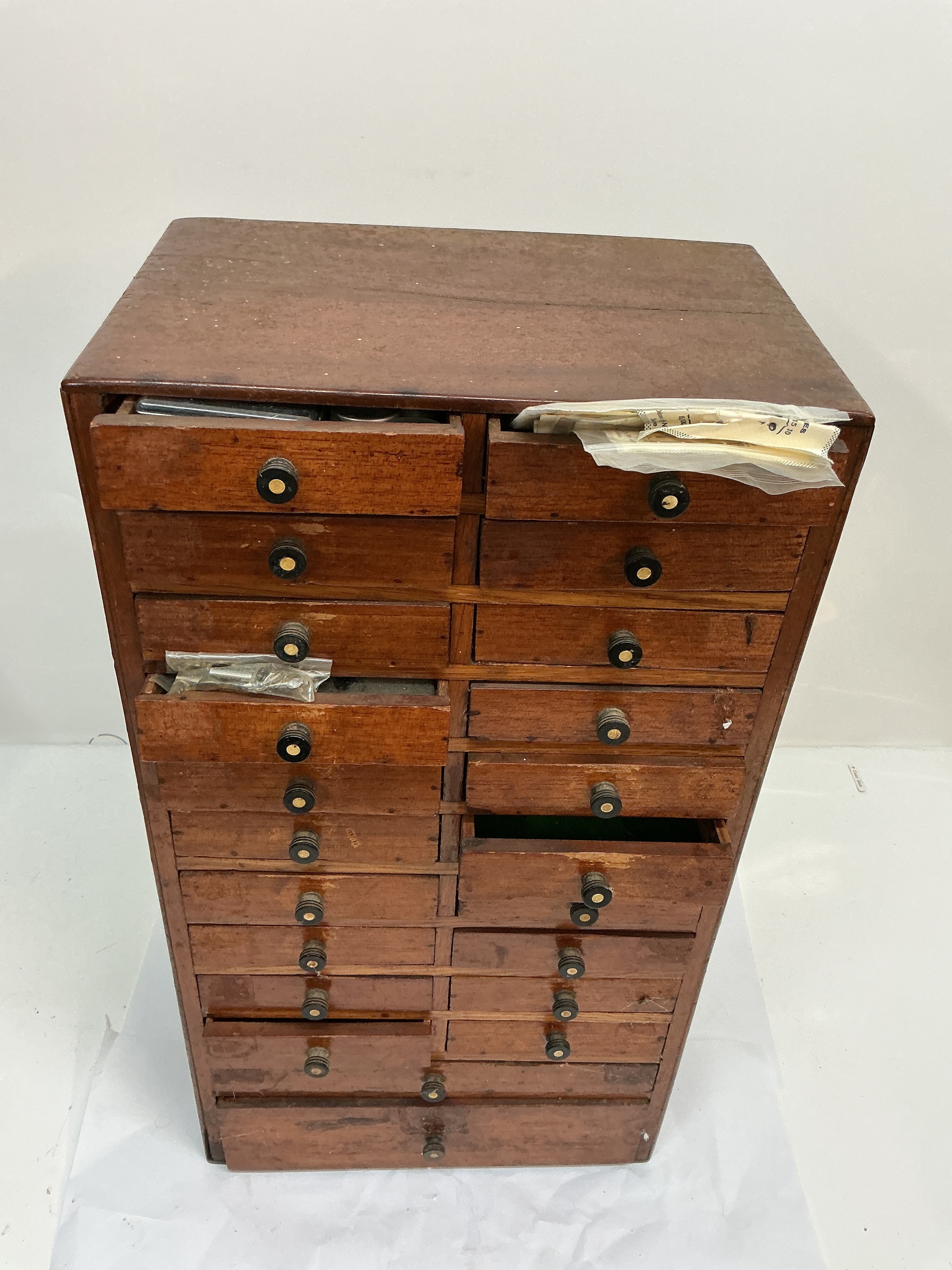 A watch maker's set of cabinet drawers including some assorted contents. Approx 18 x 47cm