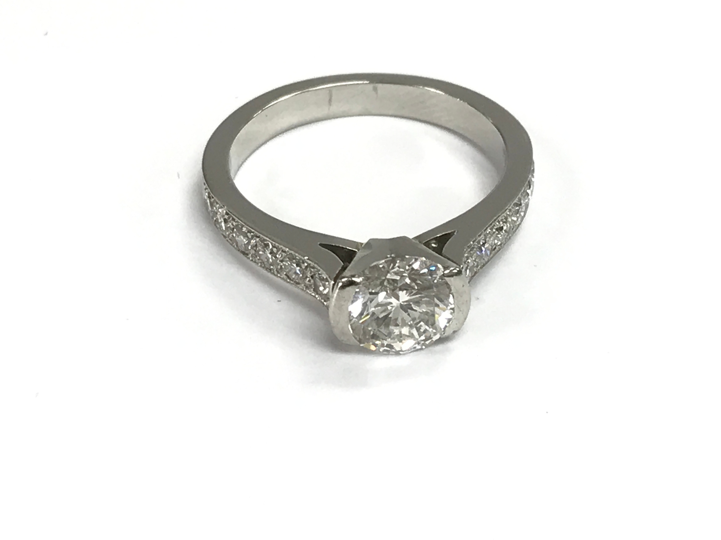 White gold diamond ring set with 1.5ct central stone and further diamonds on the shoulders. Size R and 8.13g.
