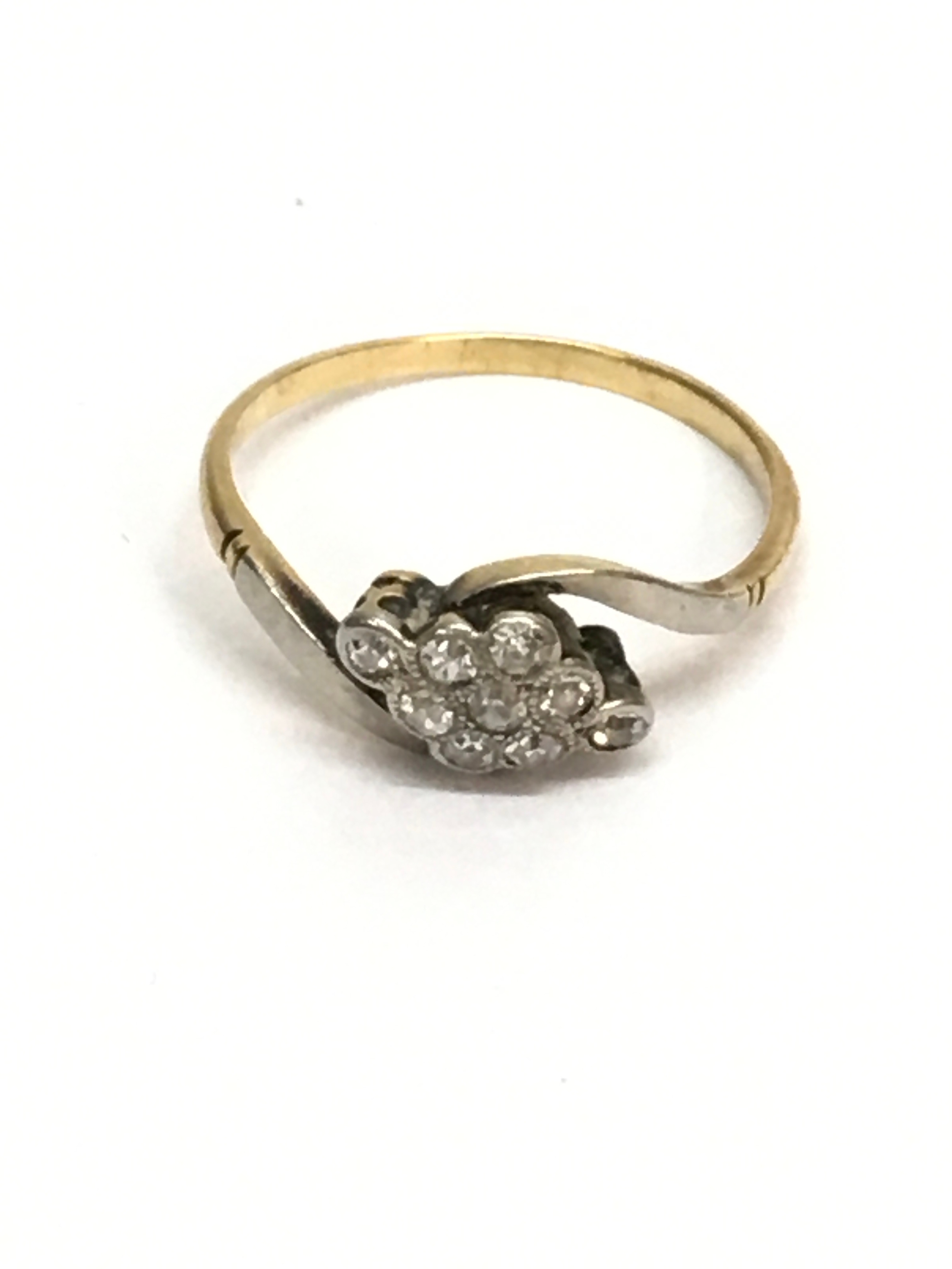An unmarked gold ring set with white stones in twist setting. Approx size o. 2.20g