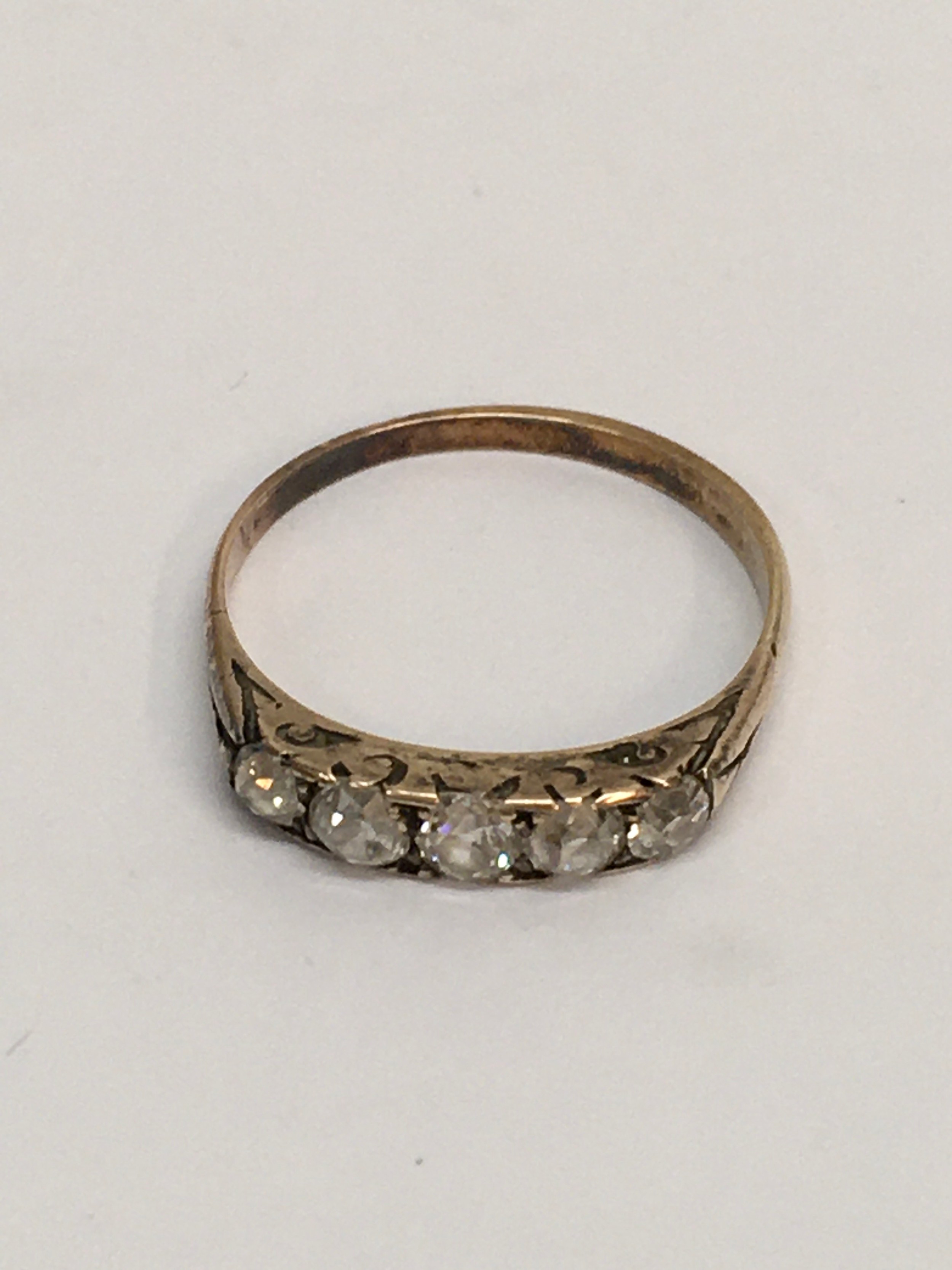 An unmarked gold ring set with old cut probable diamonds. Approx size P, 1,75g. Untested stones.