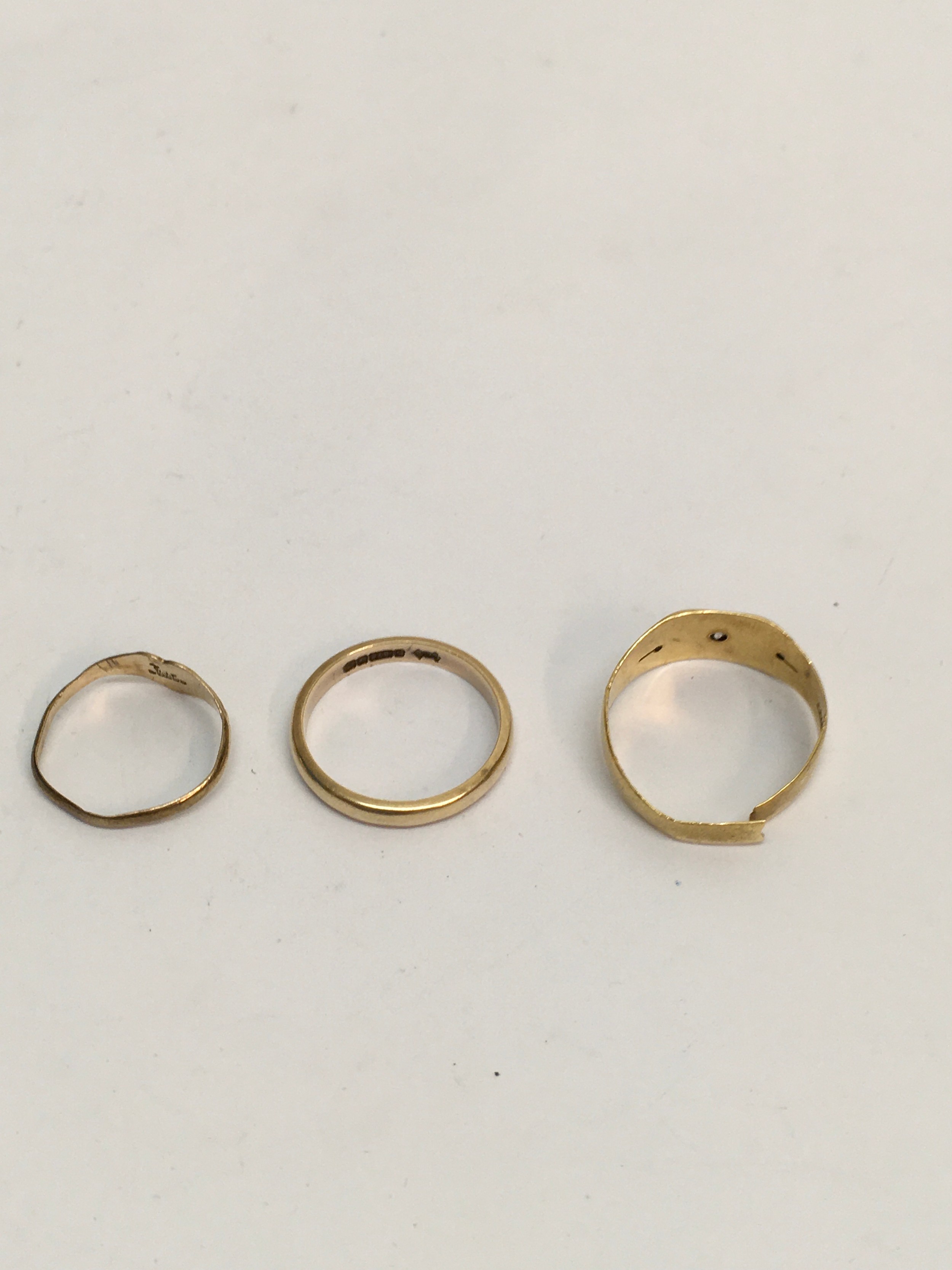 An 18ct 750 gold gent's ring set with white chip stone, a 9ct gold wedding band and child's signet ring. Two rings a/f. Approx:: 5.56g