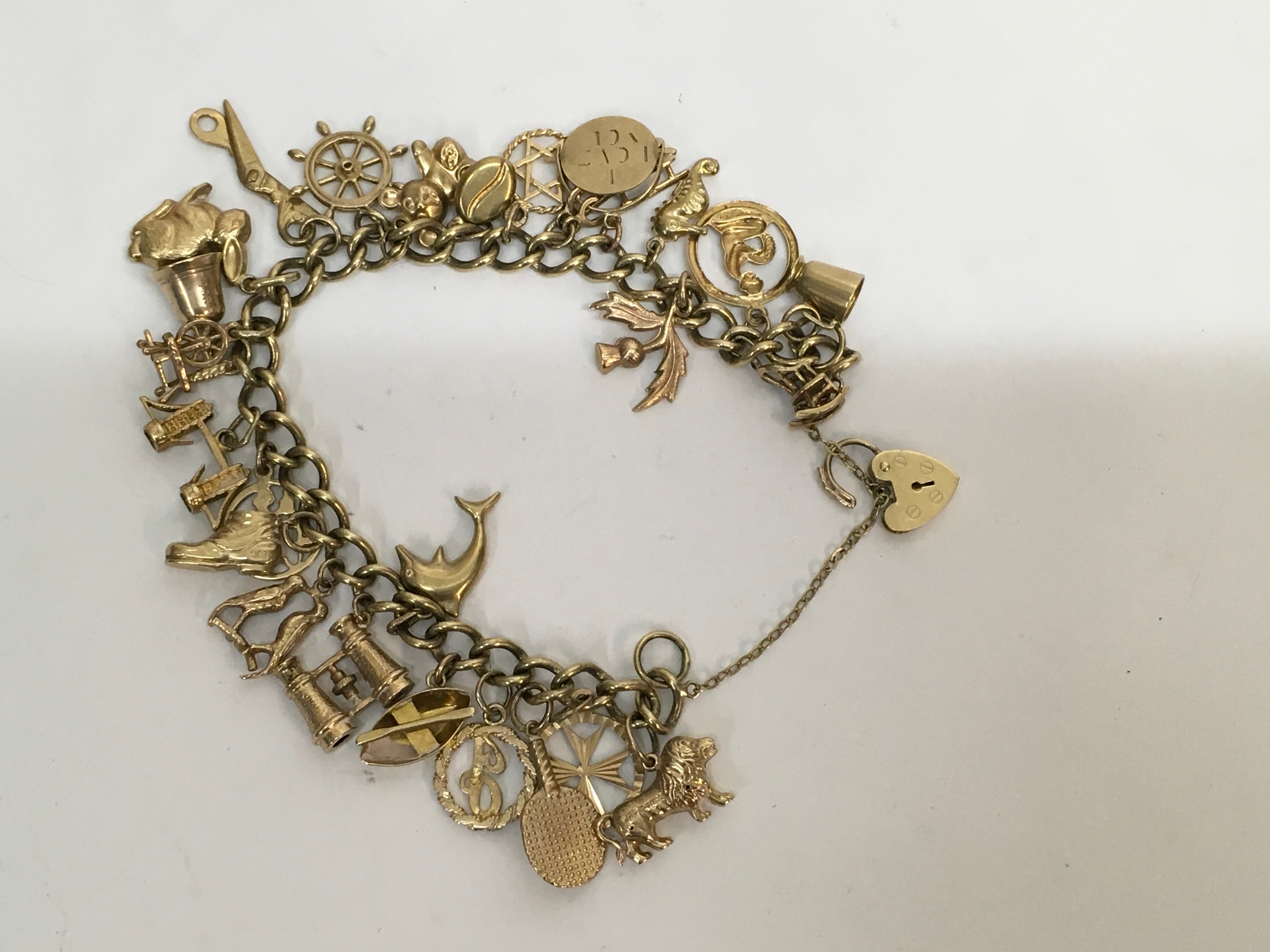 A 9ct gold charm bracelet set with various charms, many stamped 9ct. Approx 35.37g