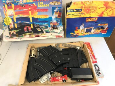 Two boxed car garages and a Grand Prix slot racing game.