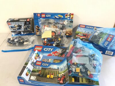 Three open Lego city sets and a Lego speed champion set.