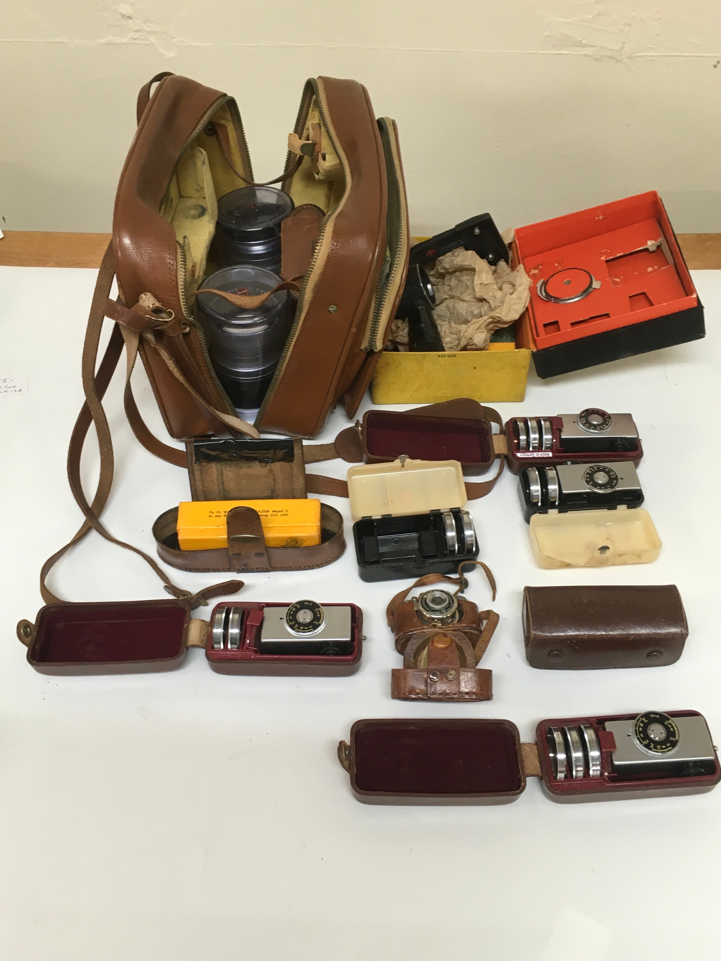  1 Mycro Sanwa camera with pouch carrier. 9Camera accessories with pouches/ cases with range finders lenses and flash equipment.