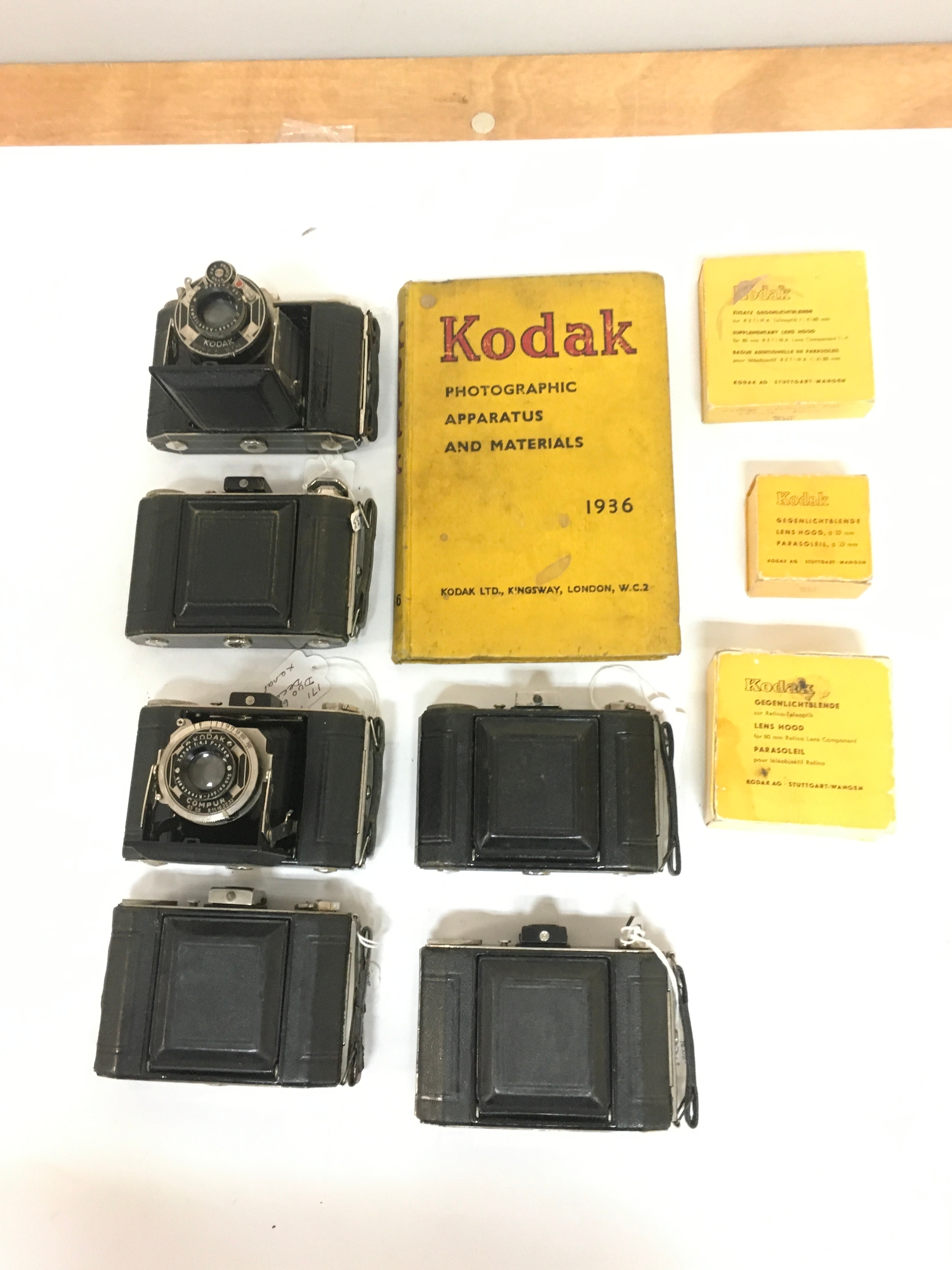 10 items; x 6 Kodak Compur cameras. A Kodak photographic Apparatus and materials book circa 1936. X 3 lens hood boxes of varying sizes.