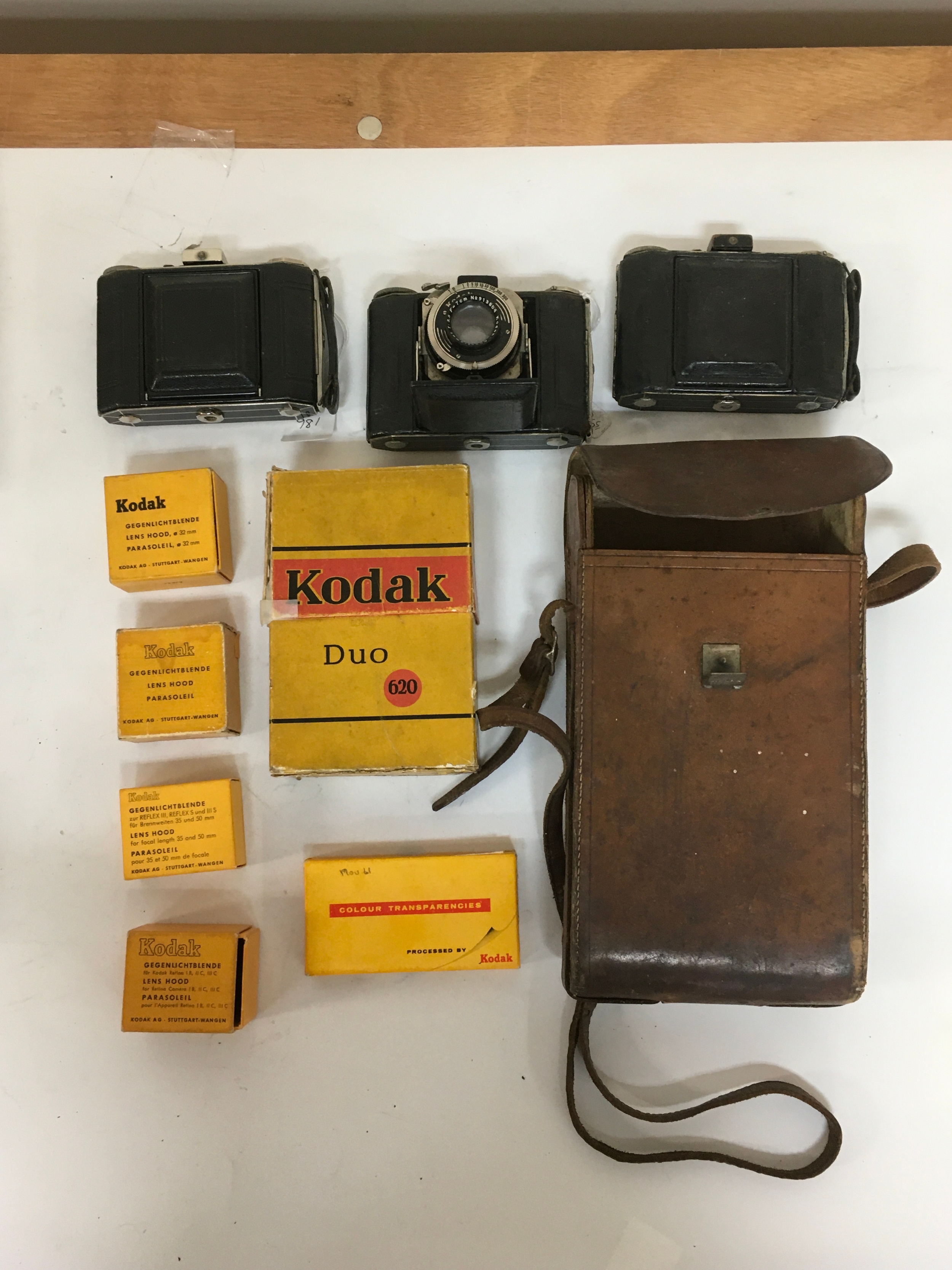 10 items, x3  Kodak duo 620 cameras, including the duo 62o box, x4 lens hood boxes. Colour transparencies and holster with camera accessories.