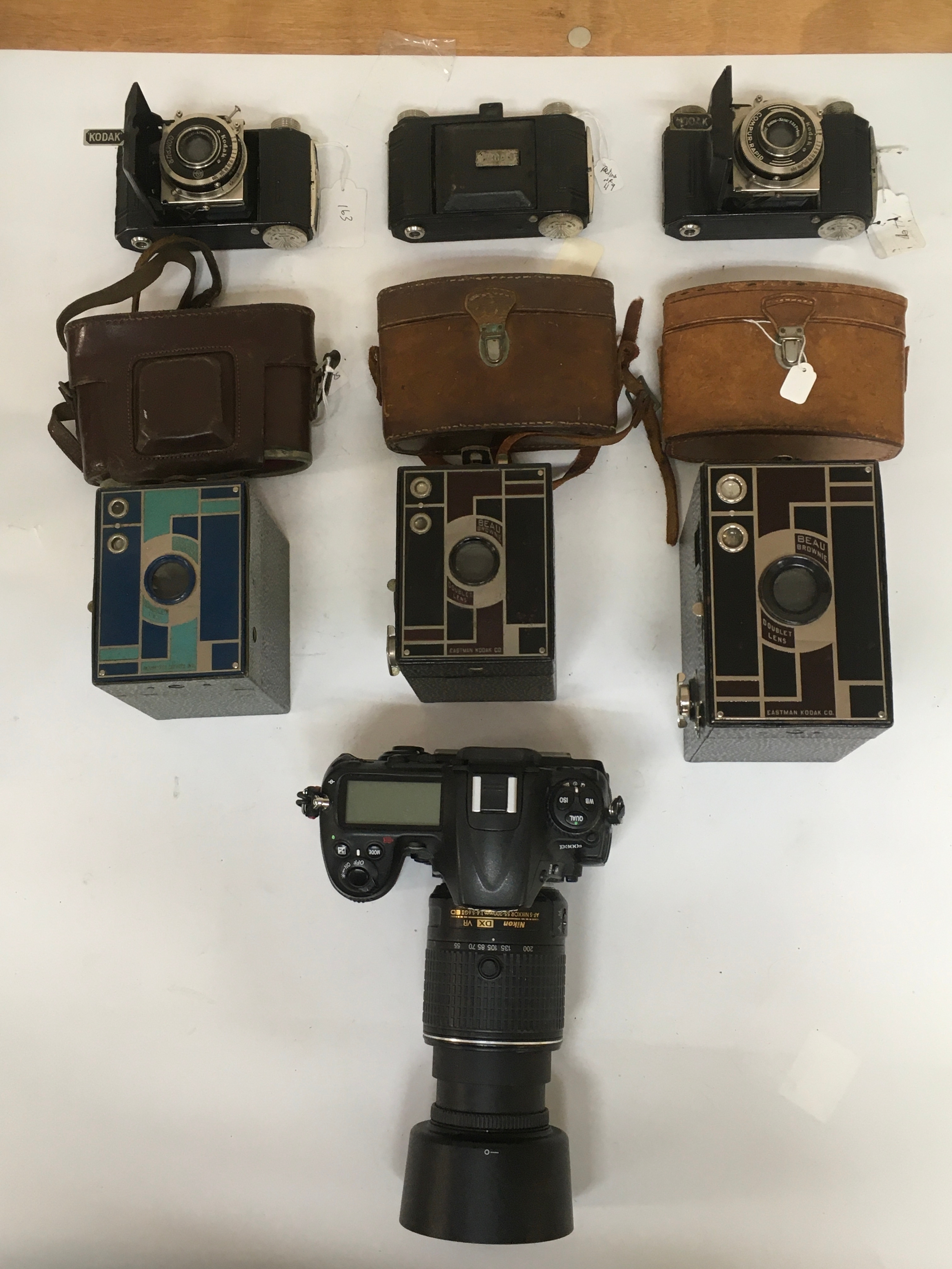 An assortment of Kodak Compur / Compur Rapid and several Beau Brownie Doublet lens cameras. A Nikon D300s Digital Camera. 3 Kodak camera carrier cases/ pouches.
