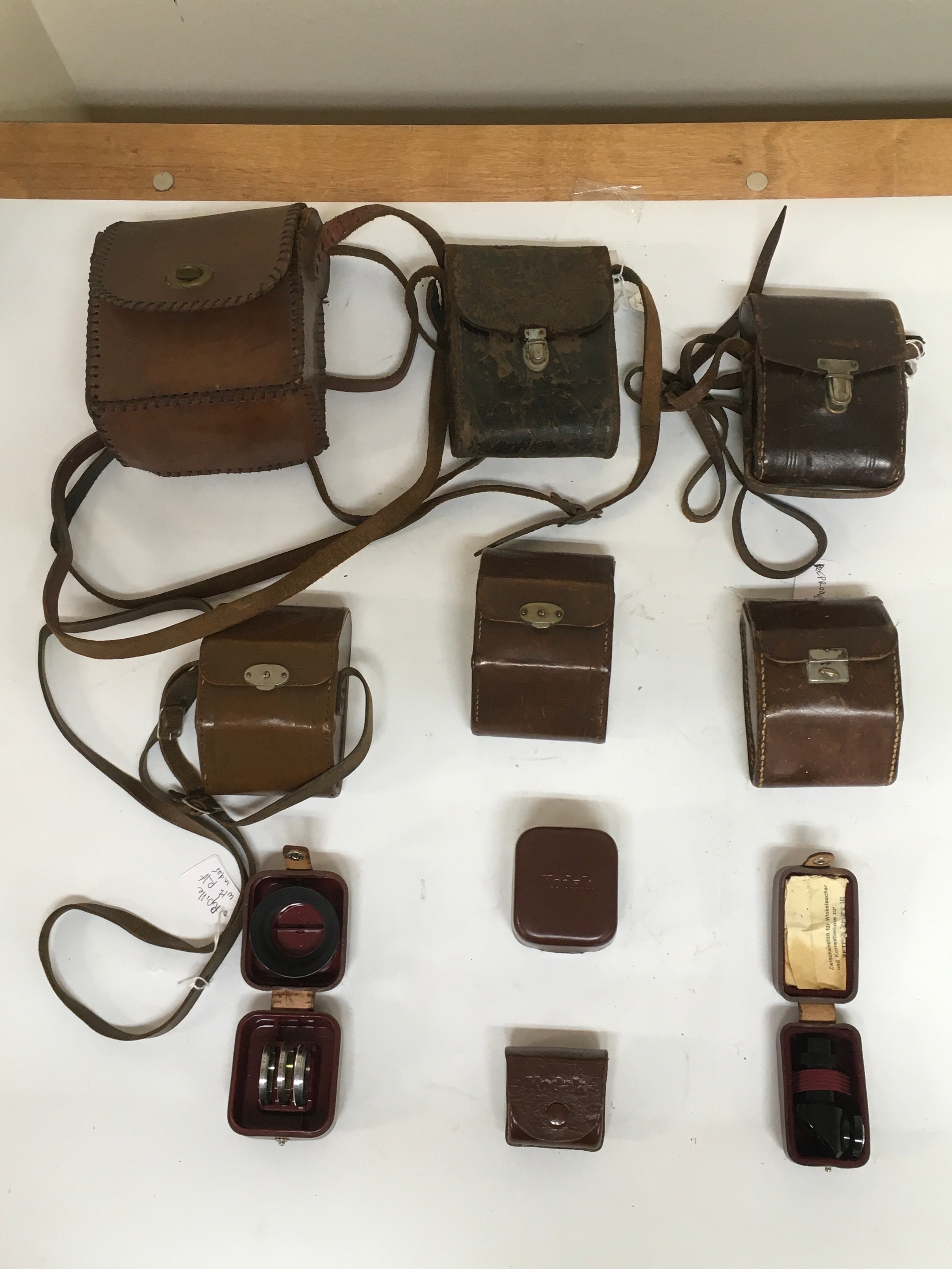 Assortment of 10 items. 6 varying camera holsters for older Kodak cameras and Purille Nagel Cameras. 4 small Kadak box/ cases with an array of camera lens equipment.