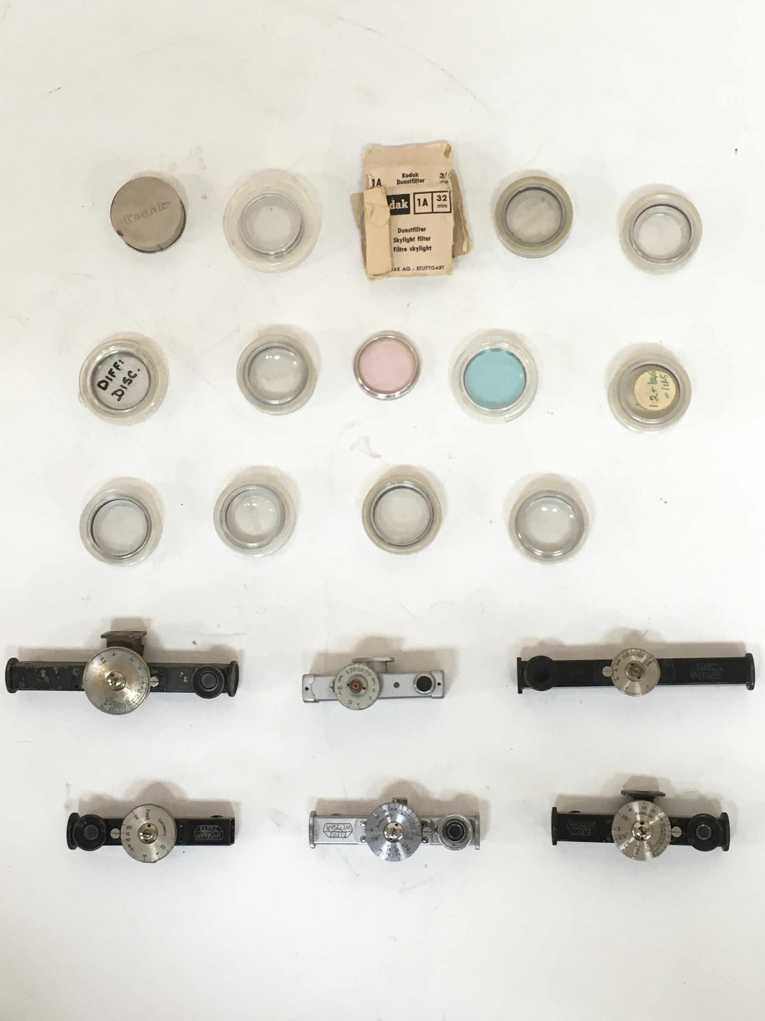 Assortment of Kodak camera lenses, sky filter and variations of range finders.
