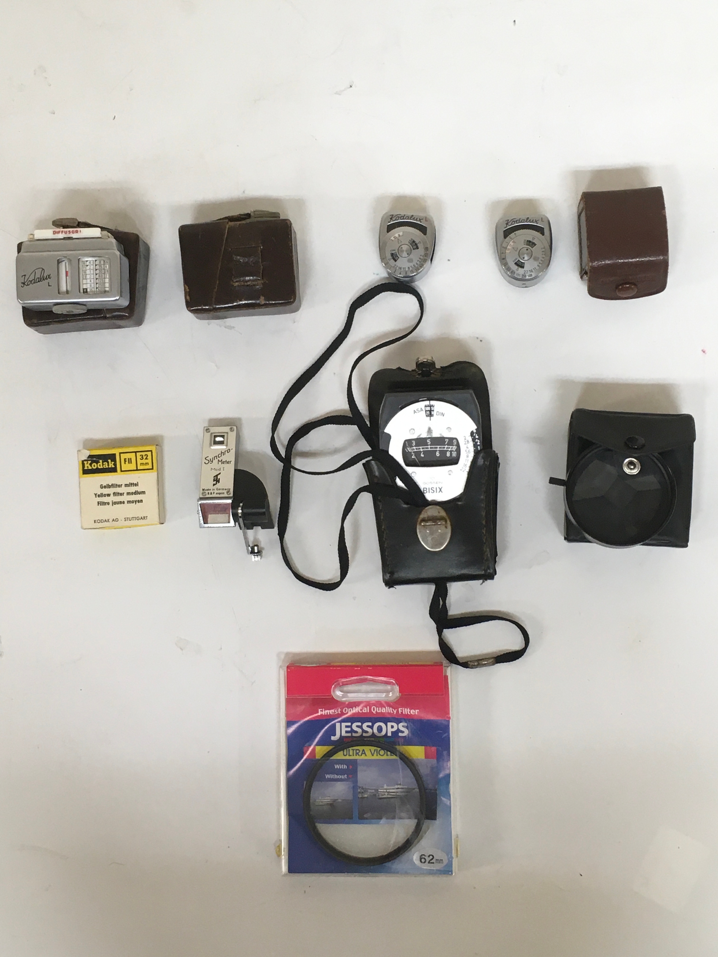 Assortment of  10 camera accessories.x 5 Kodalux  x 1 Gossen BISIX, Exposure Meter readers. Synchro meter. Camera lens with pouch. Yellow filter medium. Jessops, Finest Optical Quality Filter.
