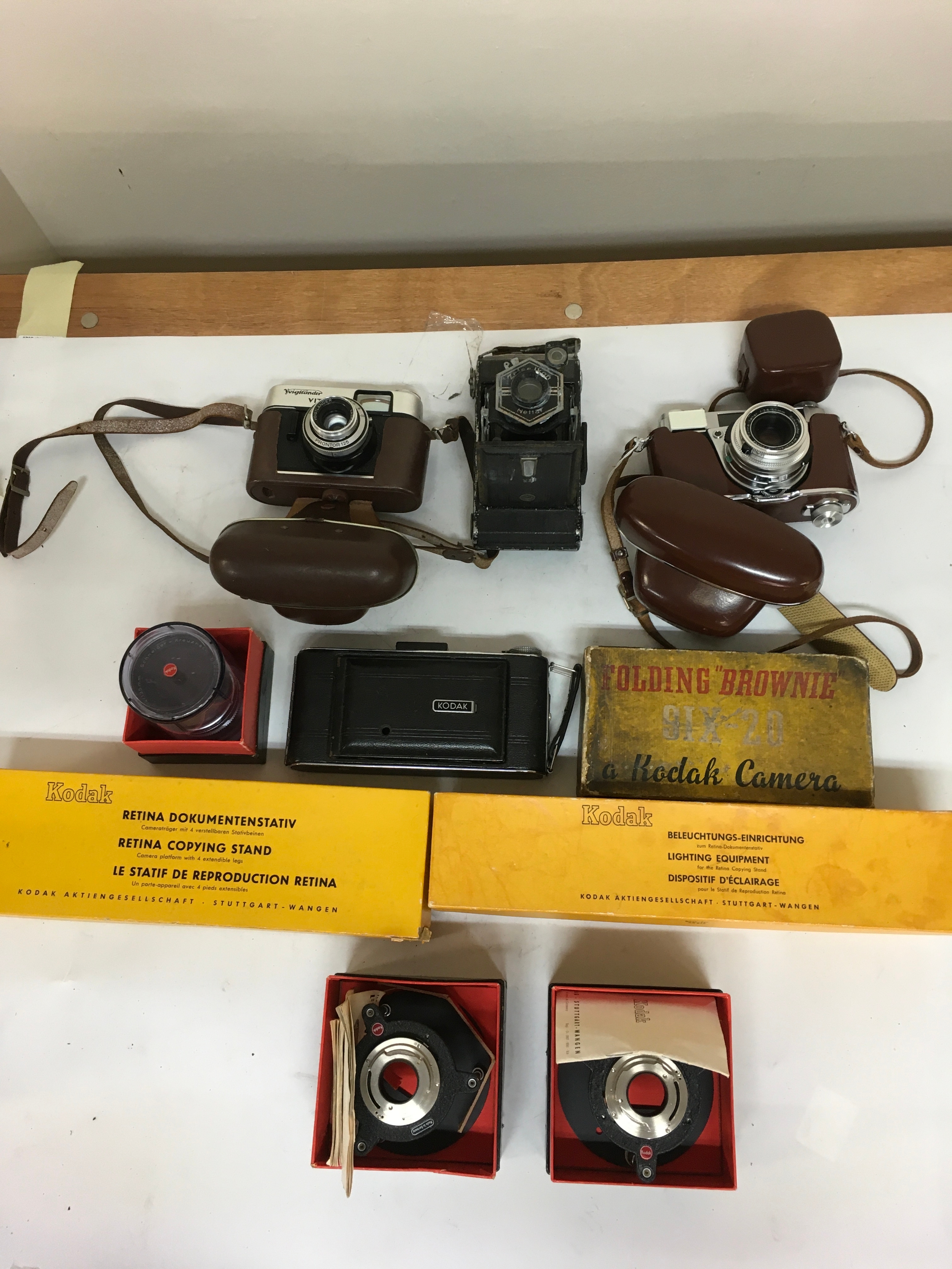 10 items. 1 Voigtlander Vitoret Prontor 125 with carrier. 1 Zeiss Ikon Nettar. 1Kodak III S with carrier.1 Kodak videographic film camera. Folding Brownie Six-20 Kodak camera. 1 Retina Copying st and, lighting equipment. 2 close - up tripod stands. Spare camera lens.