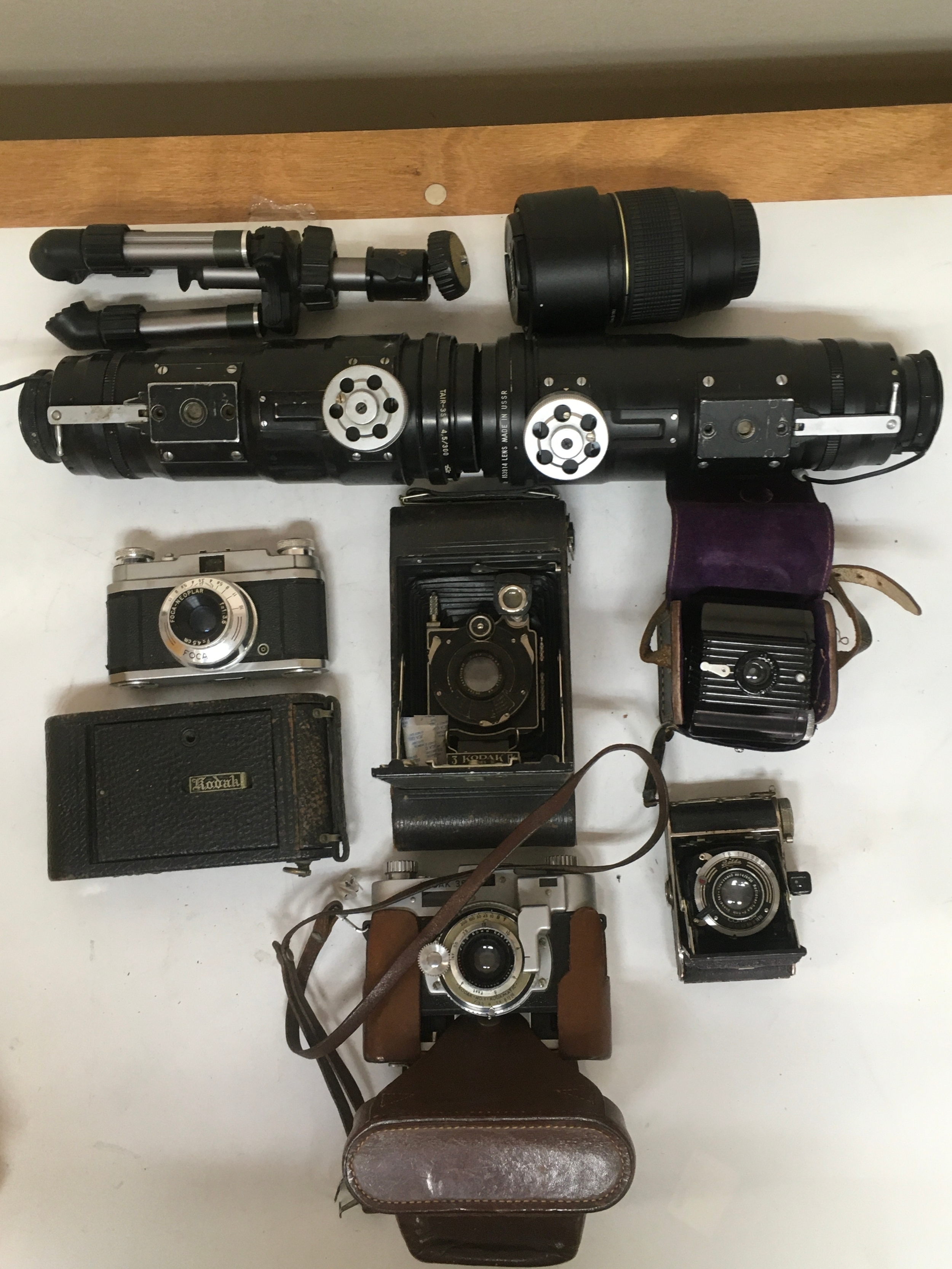 10 items.  Kodak series 3 Anastigmat camera. 1 Balda Compur. 1 Baby Brownie with holster carrier.  Kodak 35 No 1 Kodamatic. 1 FOCA-NEOPLAR sport. 1 Kodak Autogrphic film camera. 2 TAIR-35 Russian lenses. Tripod stand. Canon Tamron lens with cap.