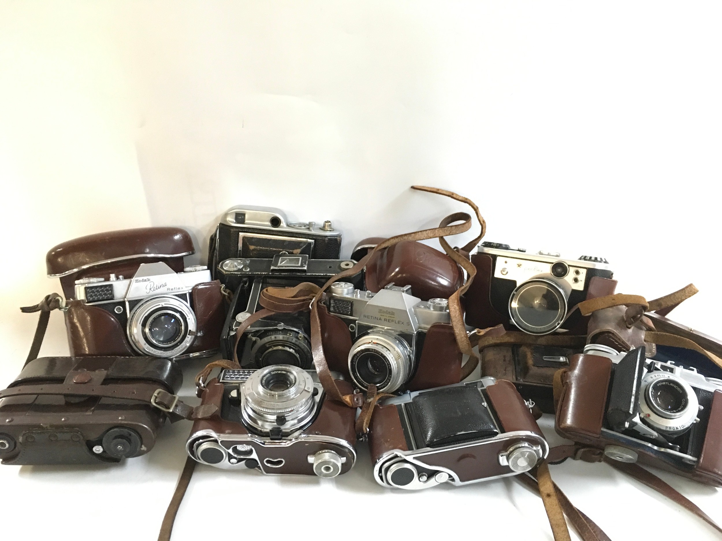 A collection of 10 vintage cameras featuring brands like Kodak, Periflex and others