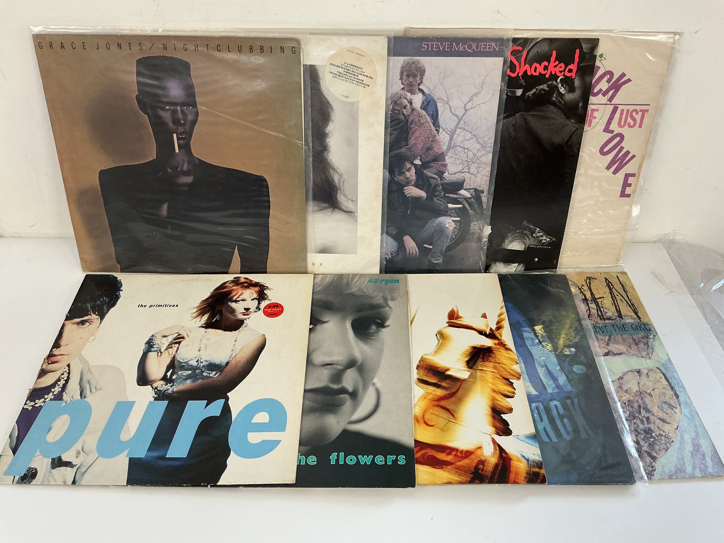Two bags containing 20 rock and pop LPs and 12" singles by various artists including Kate Bush, Grace Jones, The Primitives and others.