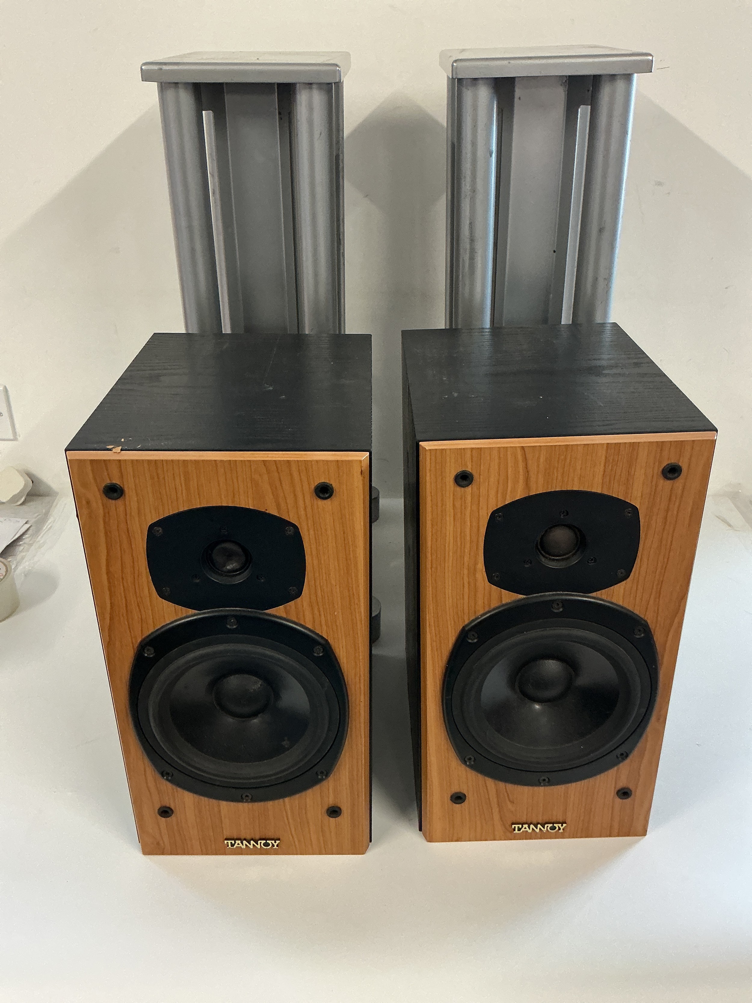 A pair of Tannoy Mercury M2.5 cherry speakers together with a pair of speaker stands and cables.