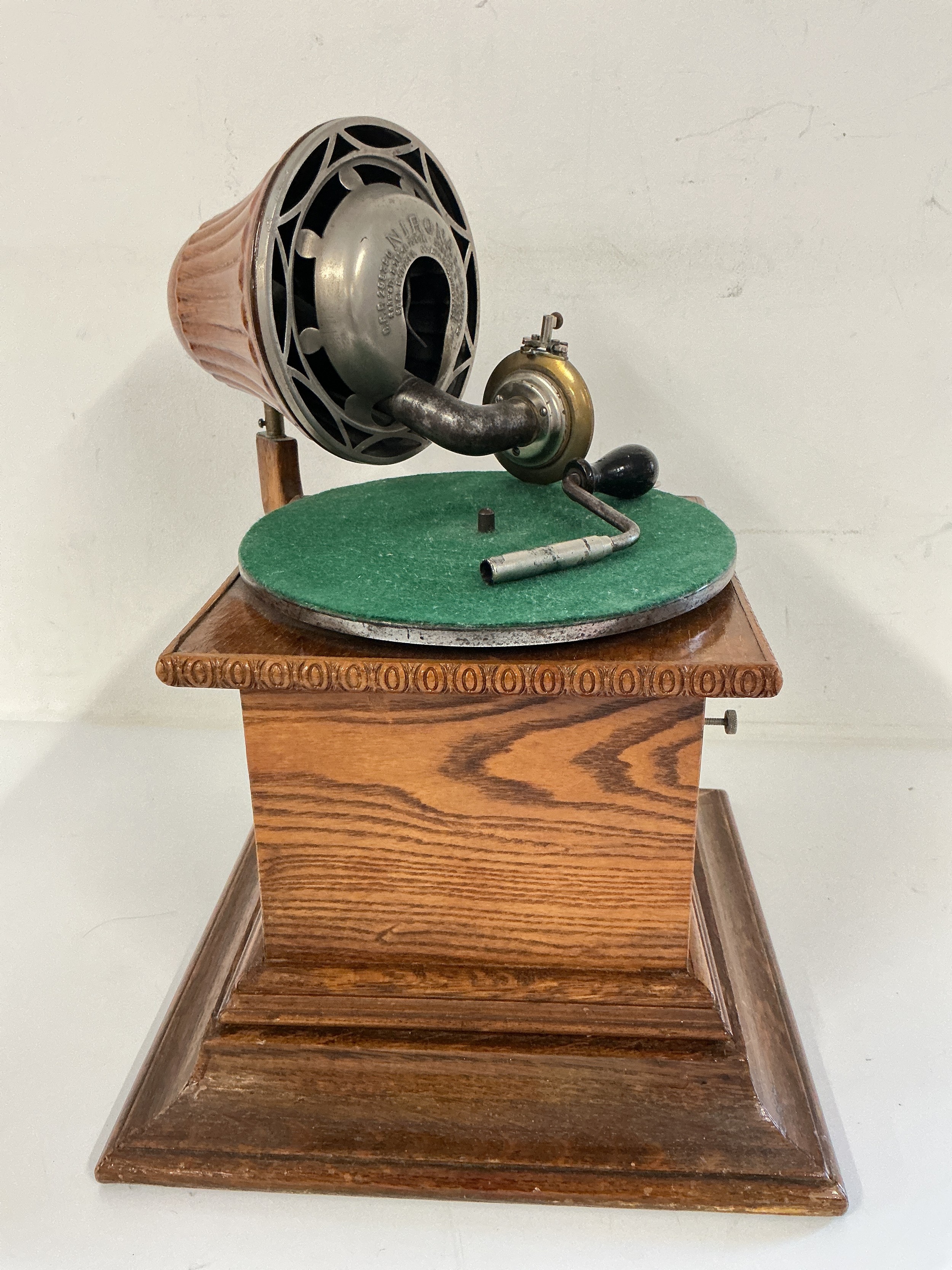 A Nirona tin plate gramophone with a carved oak base.