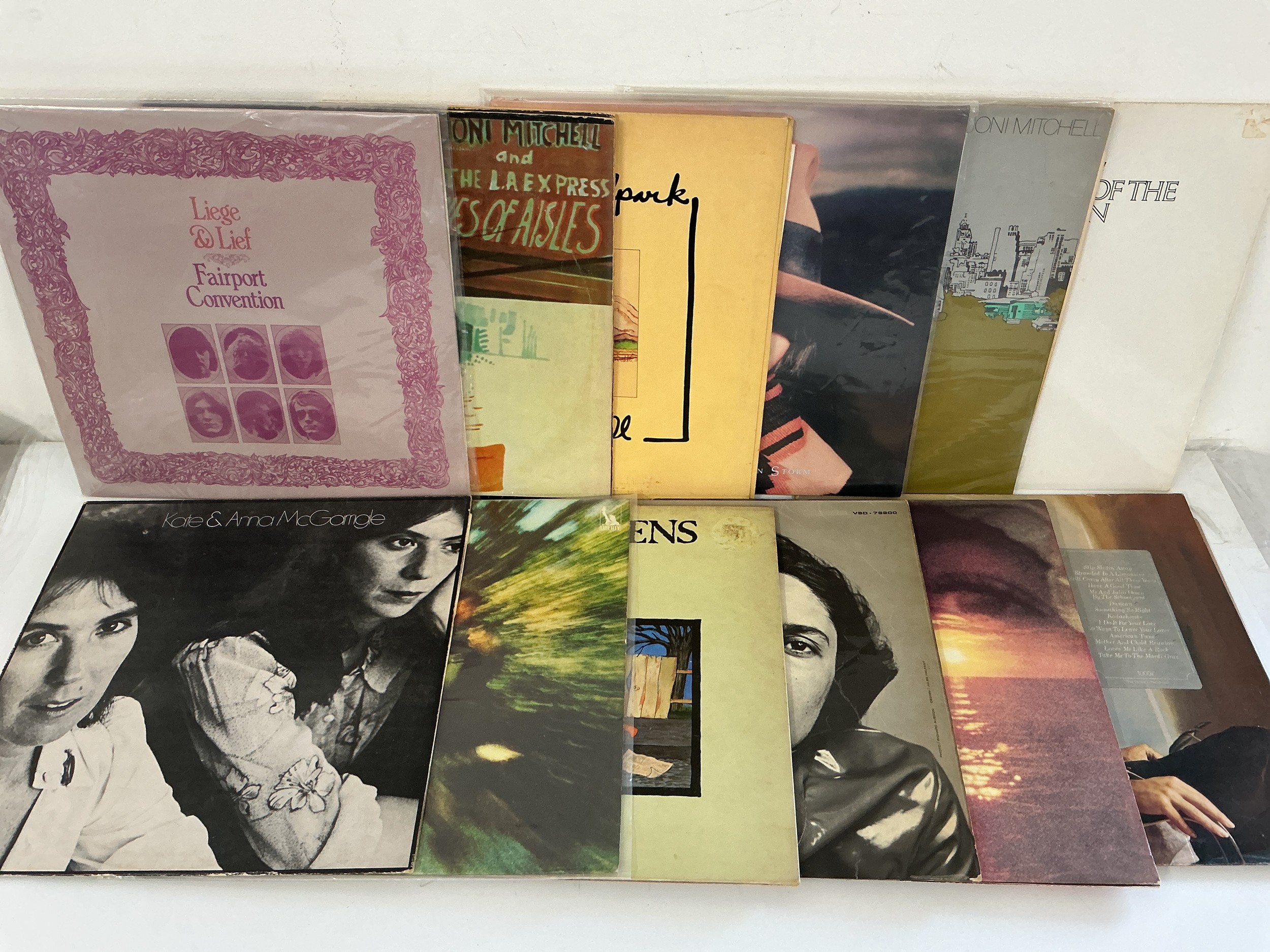 Twelve folk rock LPs by various artists including Joni Mitchell, Fairport Convention, Paul Simon and others.