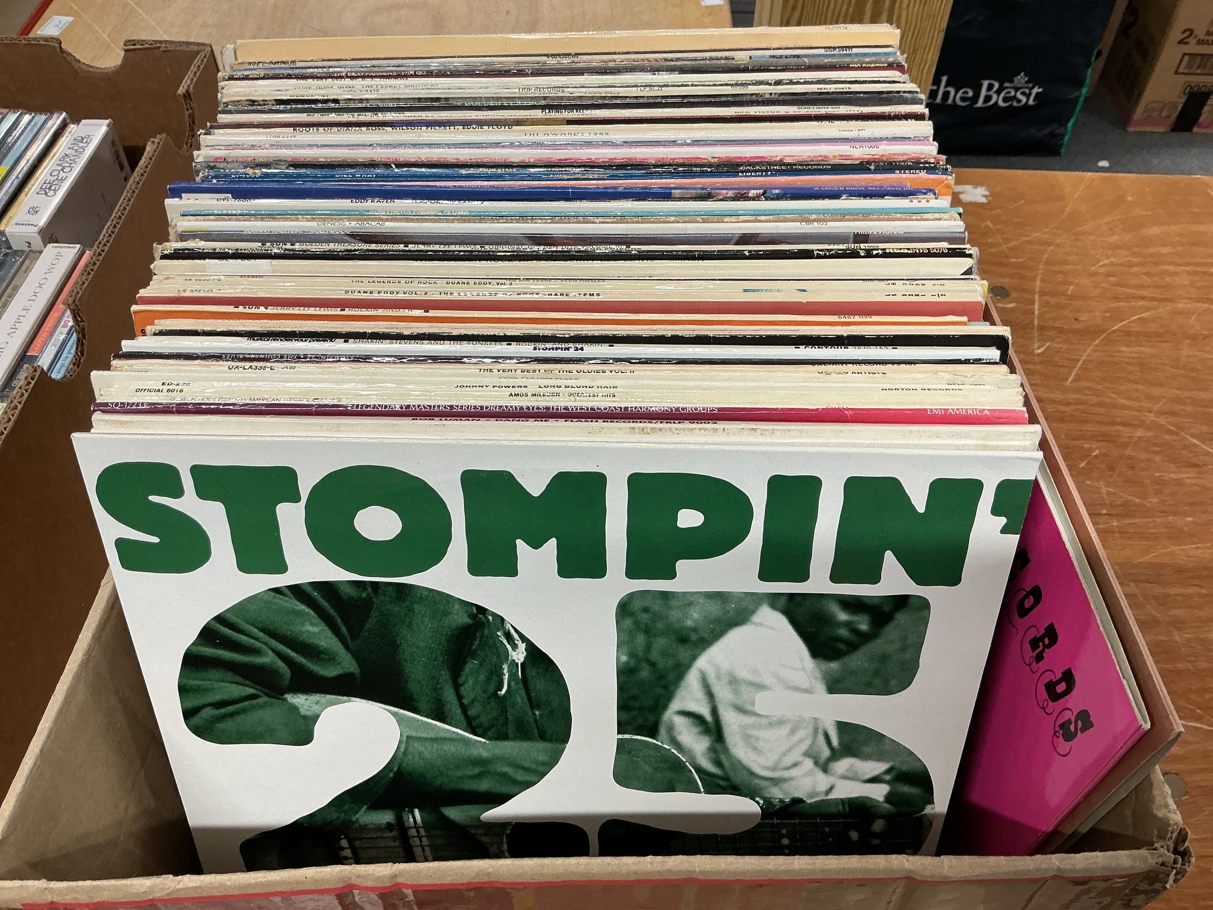 A box of LPs and 12" singles by various artists including blues and rockabilly titles.