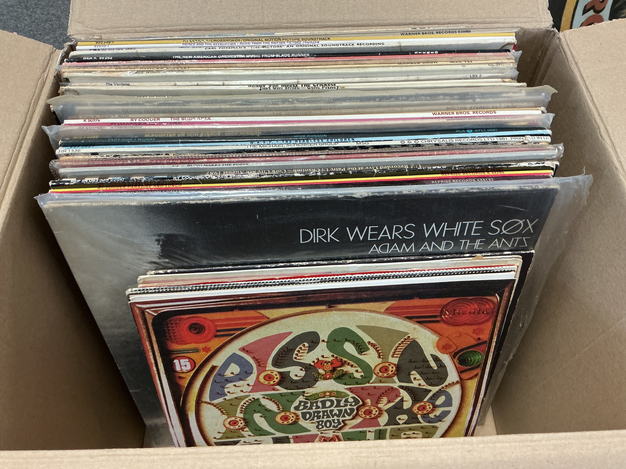 A box of LPs and 10" records by various artists including Prince, Mick Ronson, Badly Drawn Boy and others.