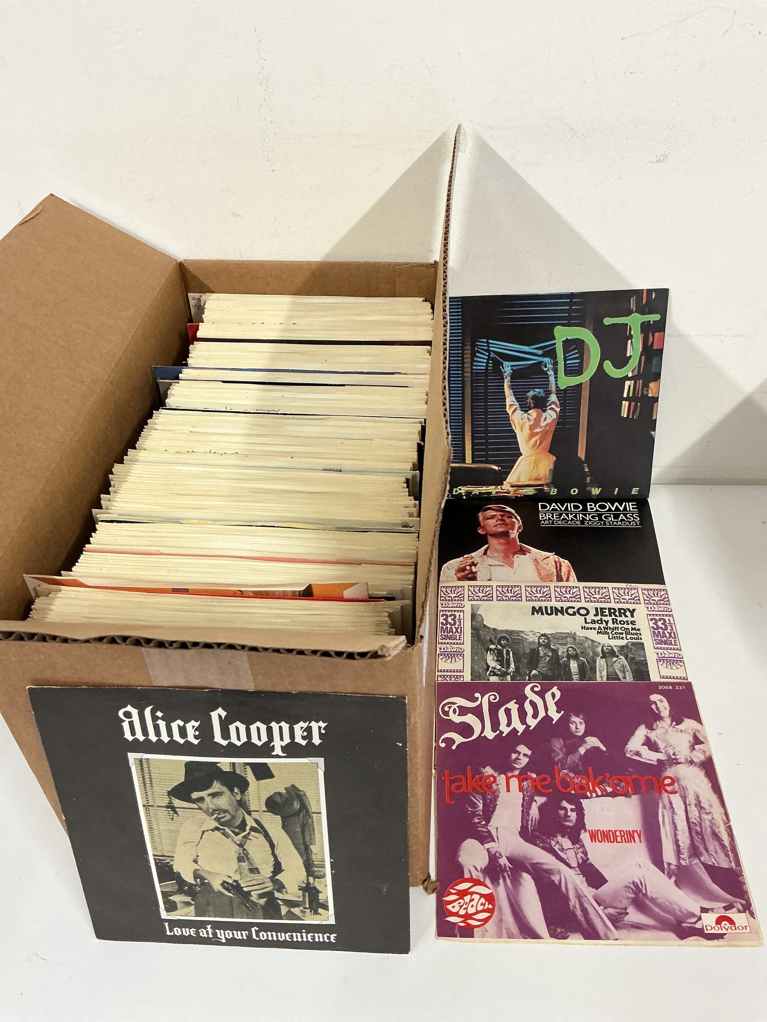 A collection of 7" singles by various artists including Alice Cooper, Queen, David Bowie and many more.
