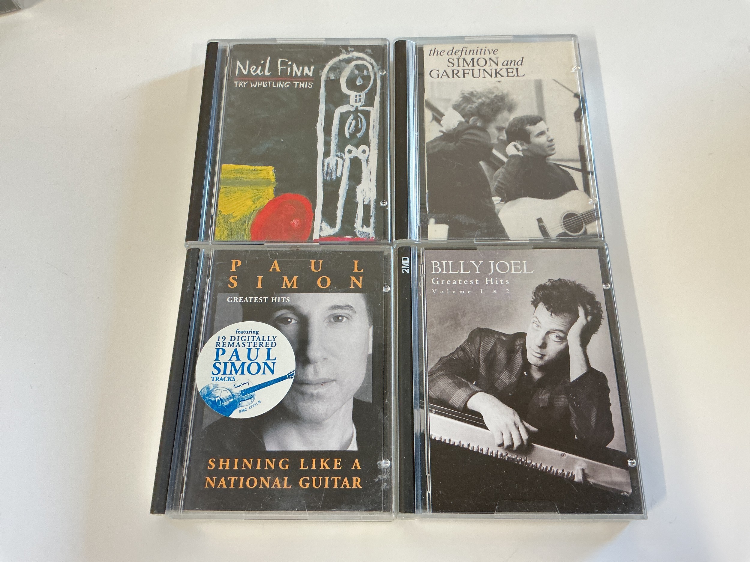 Four minidiscs by various artists comprising Simon & Garfunkel, Billy Joel and Neil Finn.