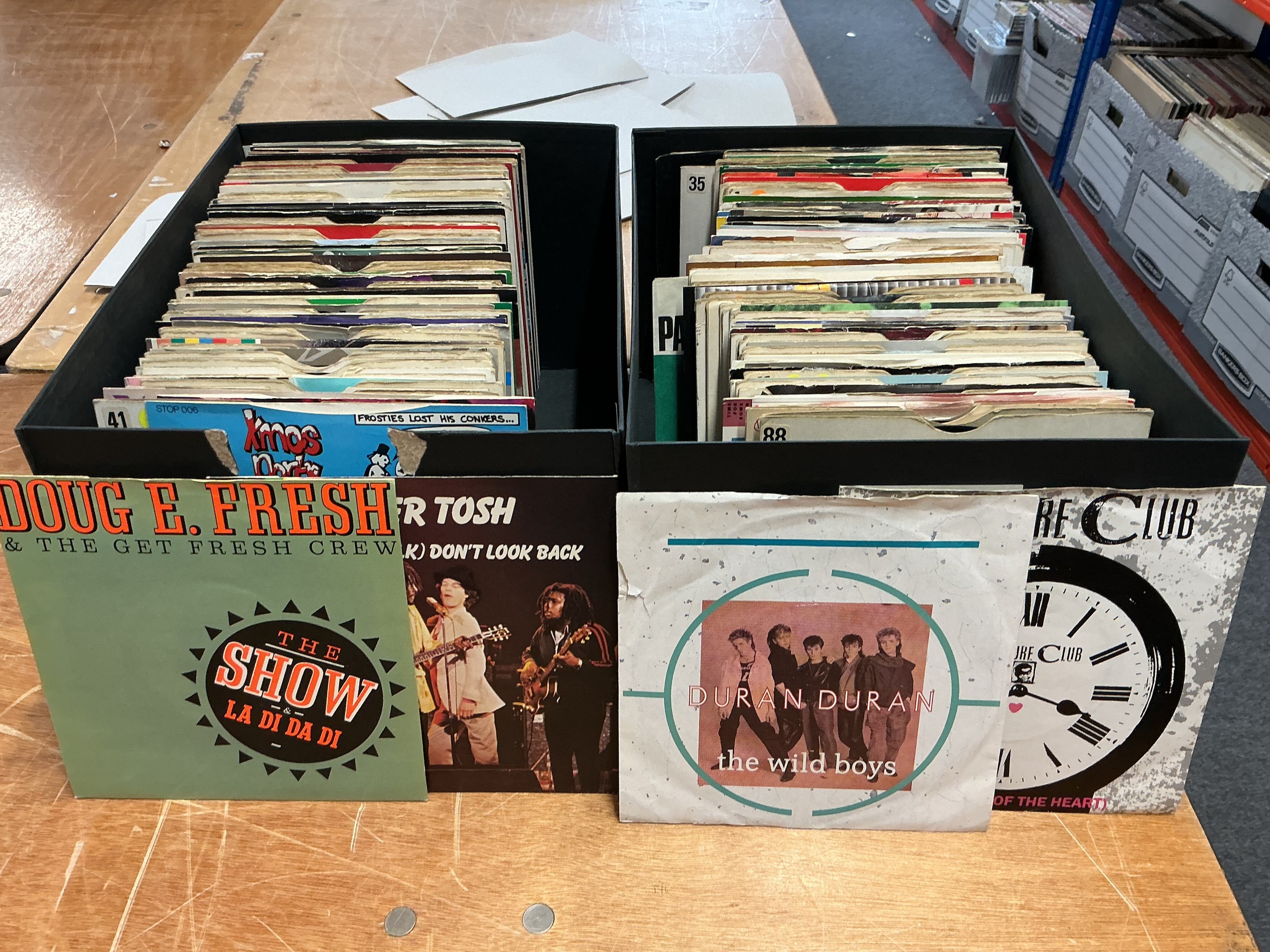 Ten boxes of 7" singles by various artists including Madonna, Prince, Peter Tosh and many more.