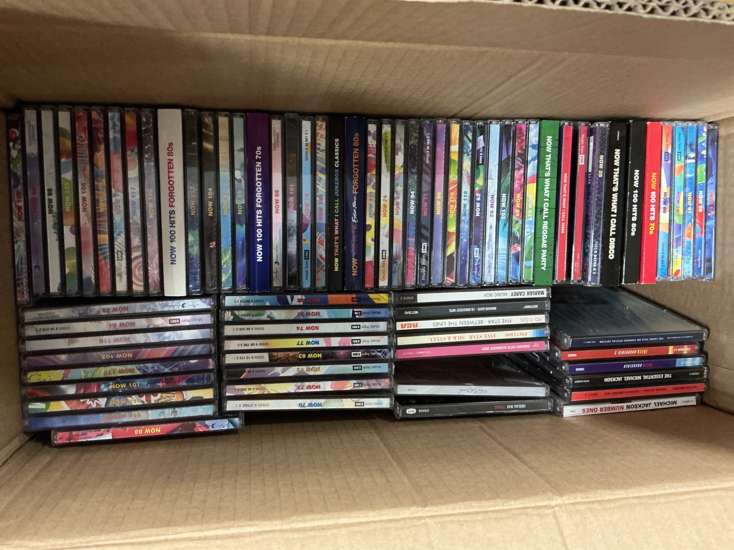 Two boxes of CDs, DVDs and BluRays including various Now compilation albums.