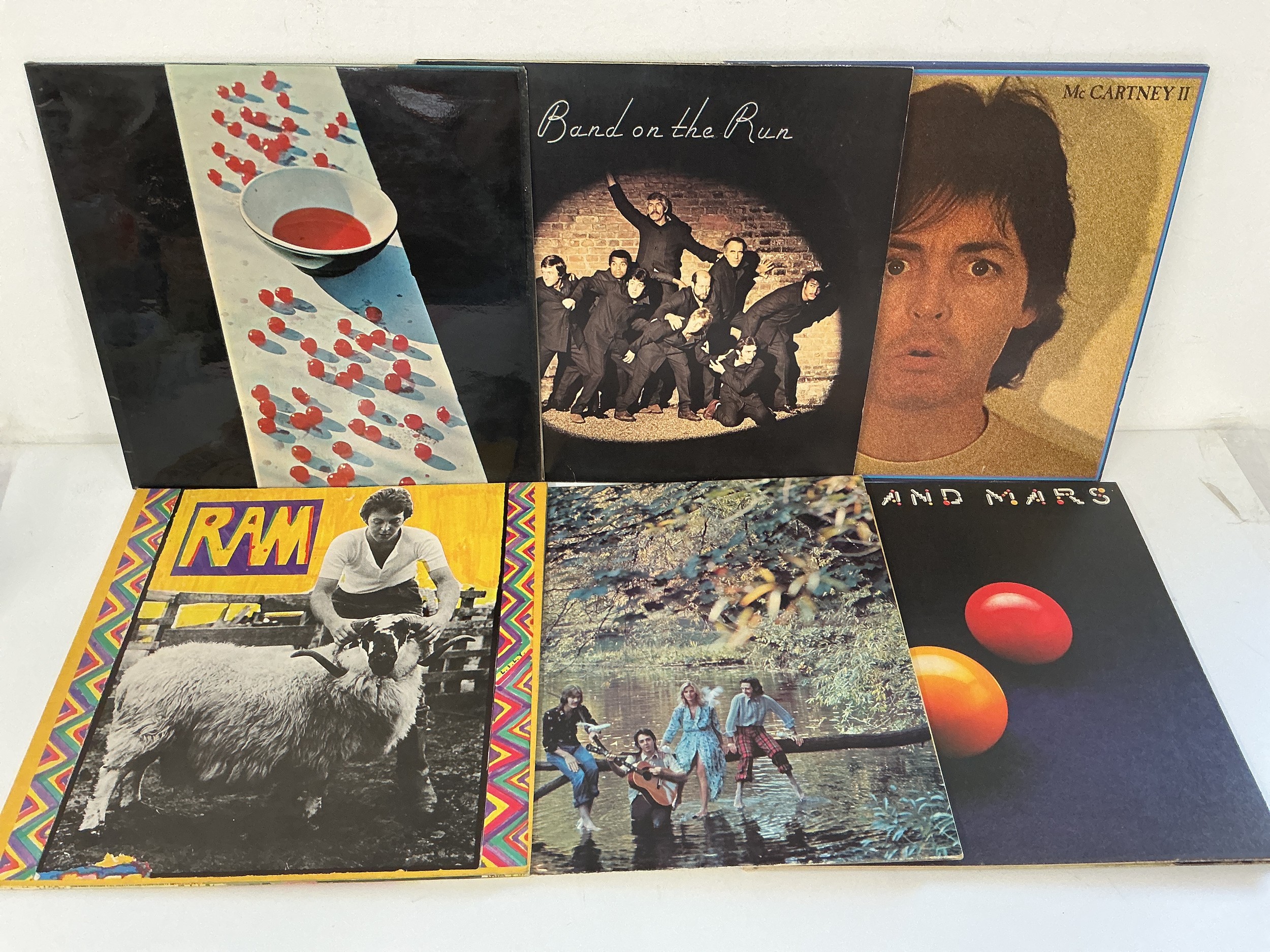 Two bags containing thirteen Paul McCartney and Wings LPs comprising Ram, McCartney II, Wild Life and others.