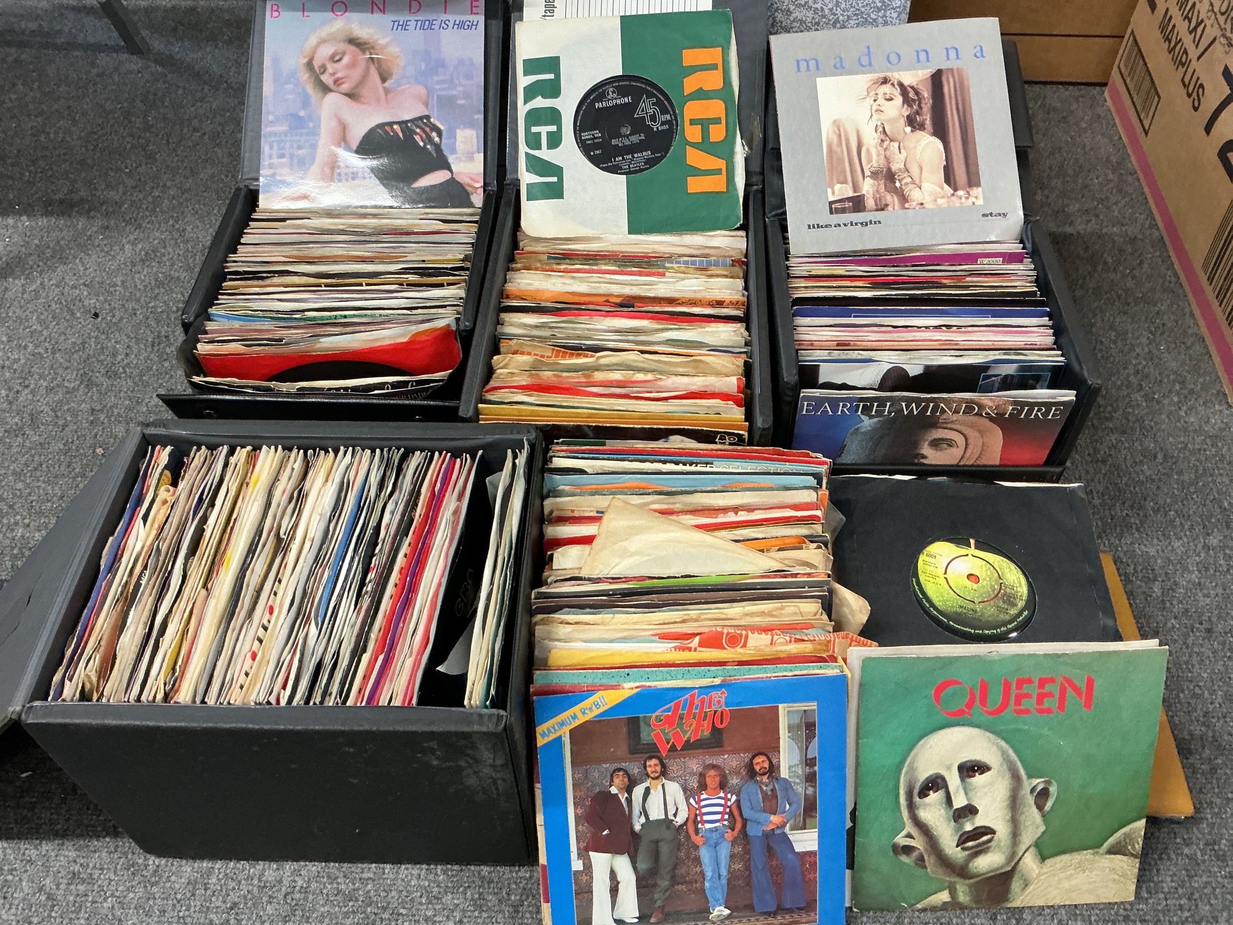 Four record cases and a box of 7" singles by various artists including Queen, T Rex, OMD and many more.