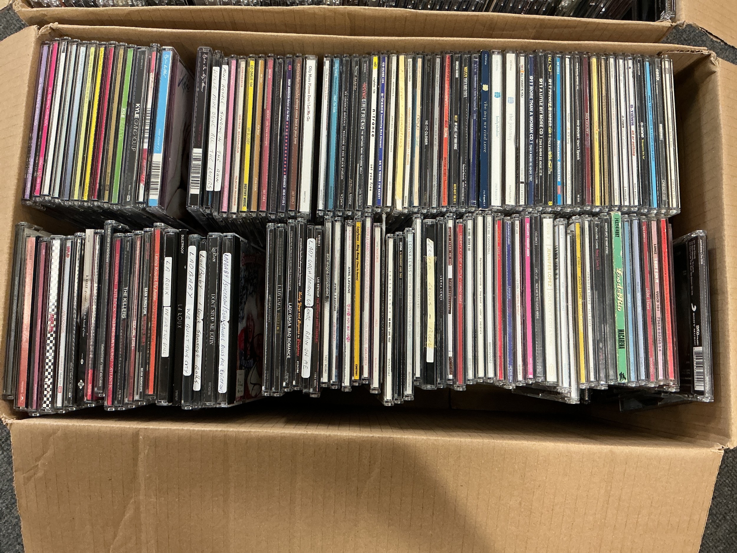 Two boxes of CD singles by various artists including Oasis, Coldplay, Fatboy Slim, Madonna and many more.