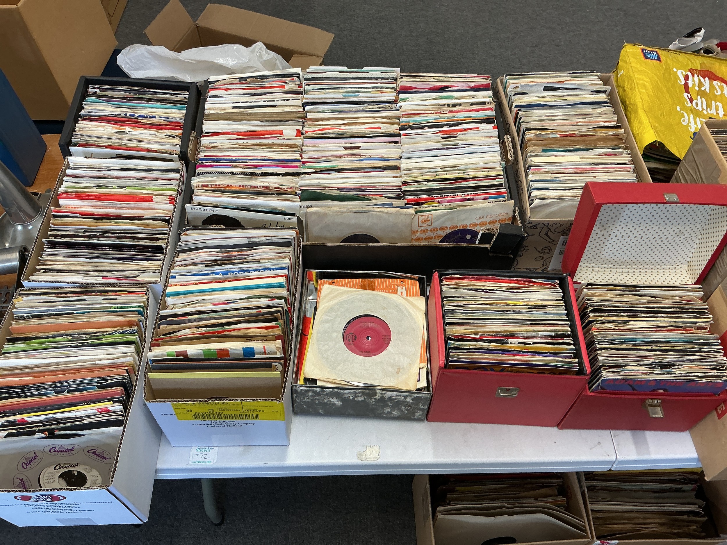 Three record cases and six small boxes of 7" singles by various artists including demo discs and promos.