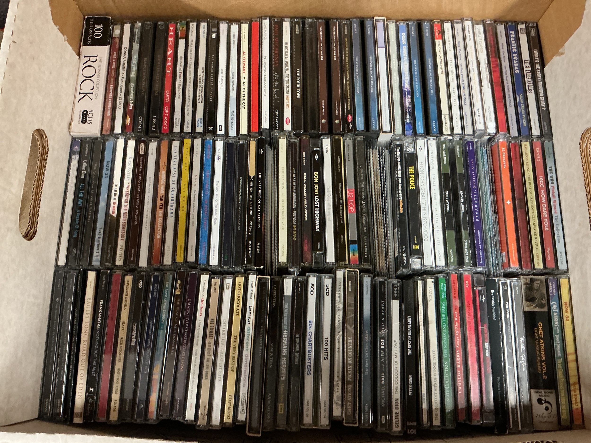 A box of CDs by various artists including REM, Paul Weller, Coldplay and many more.