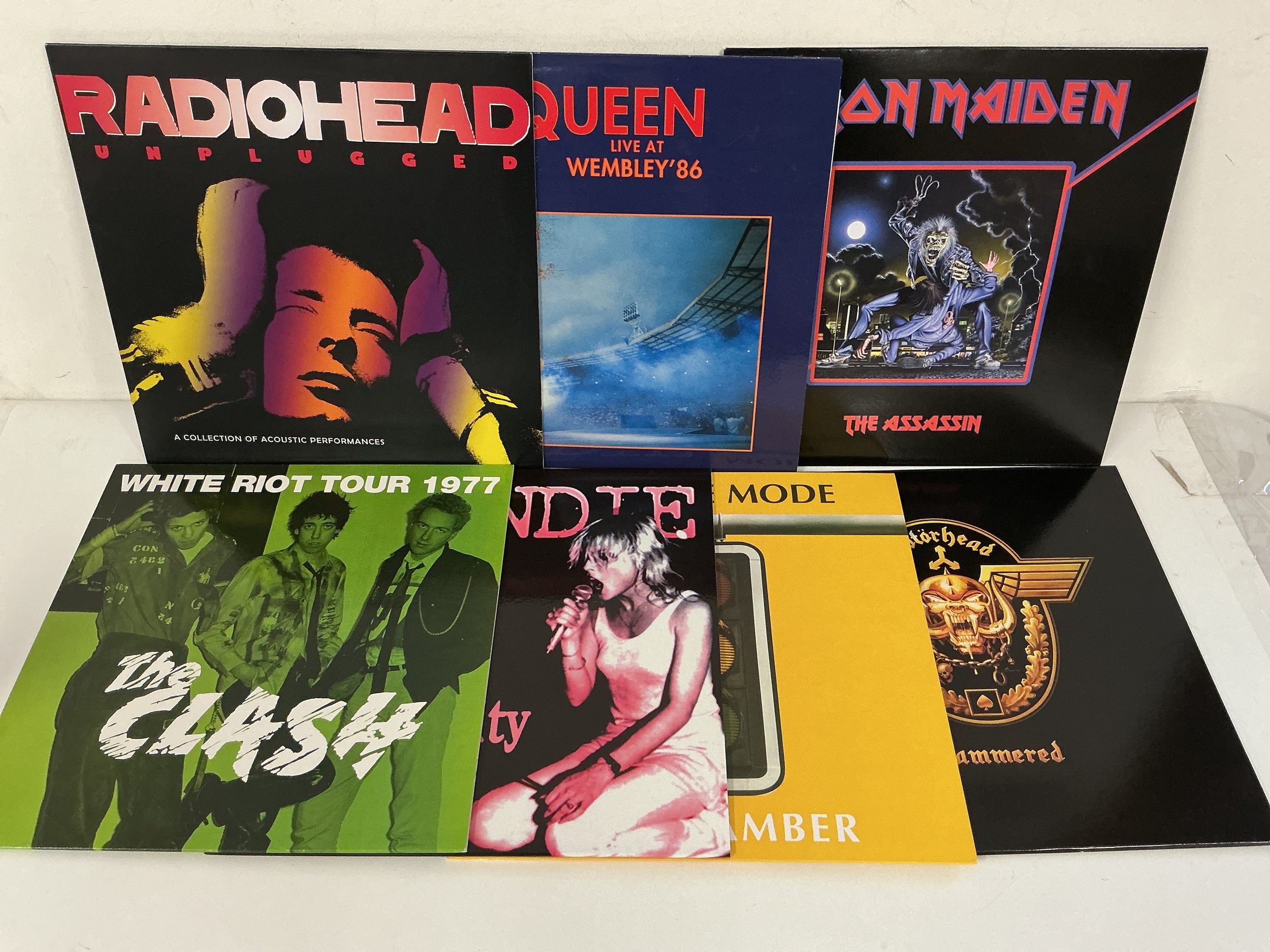 Seven rock LPs by various artists including Queen, The Clash, Iron Maiden and others.
