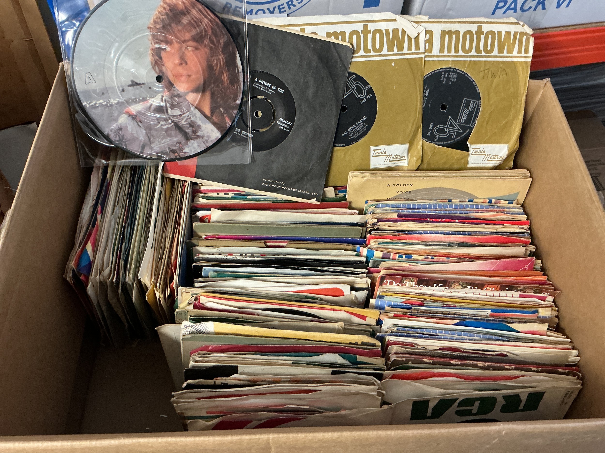A record case and a box of 7" singles by various artists from the 1960s onwards.