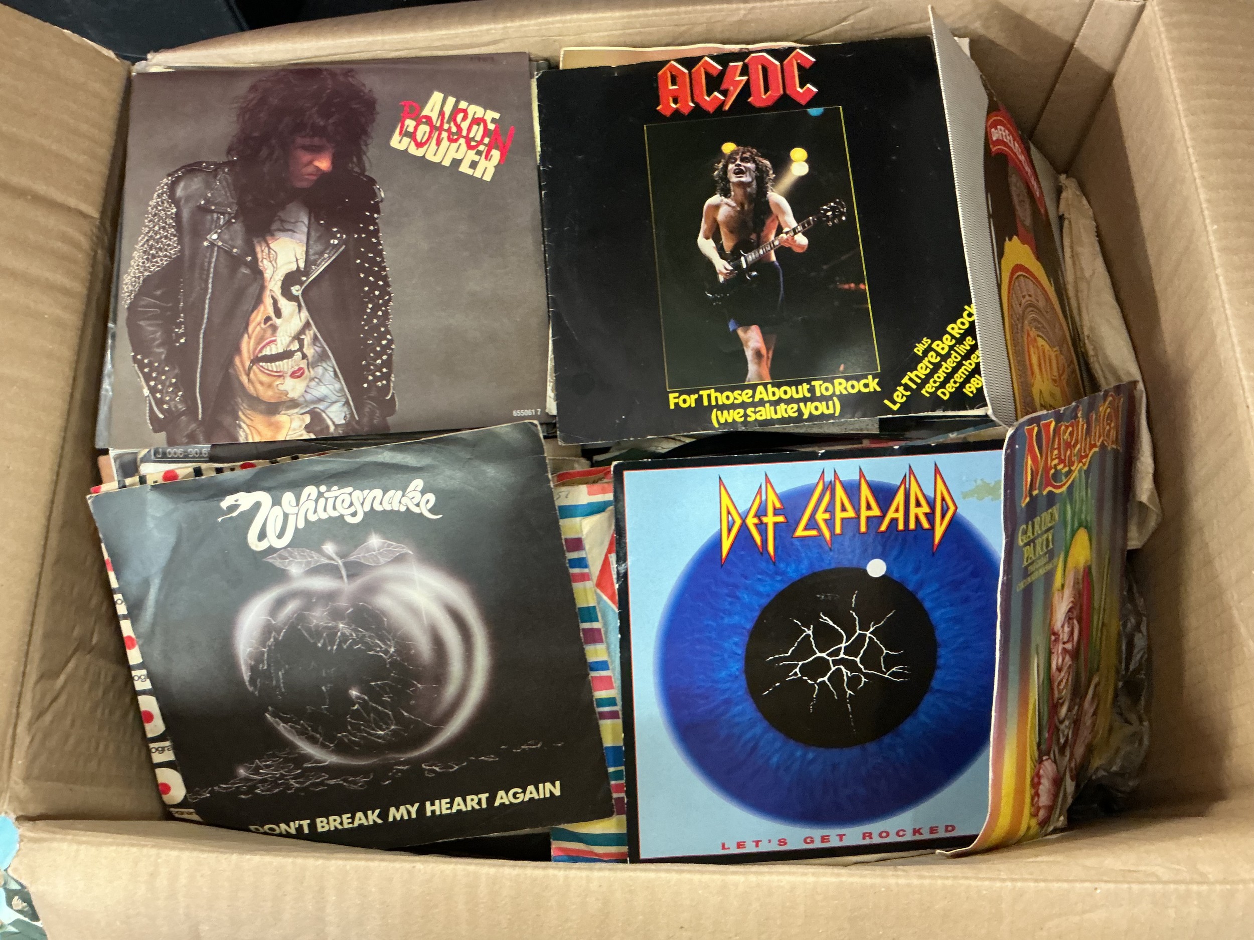 Two boxes of 7" singles and EPs by various artists including Alice Cooper, Marillion, AC/DC, The Rolling Stones, David Bowie and many more.