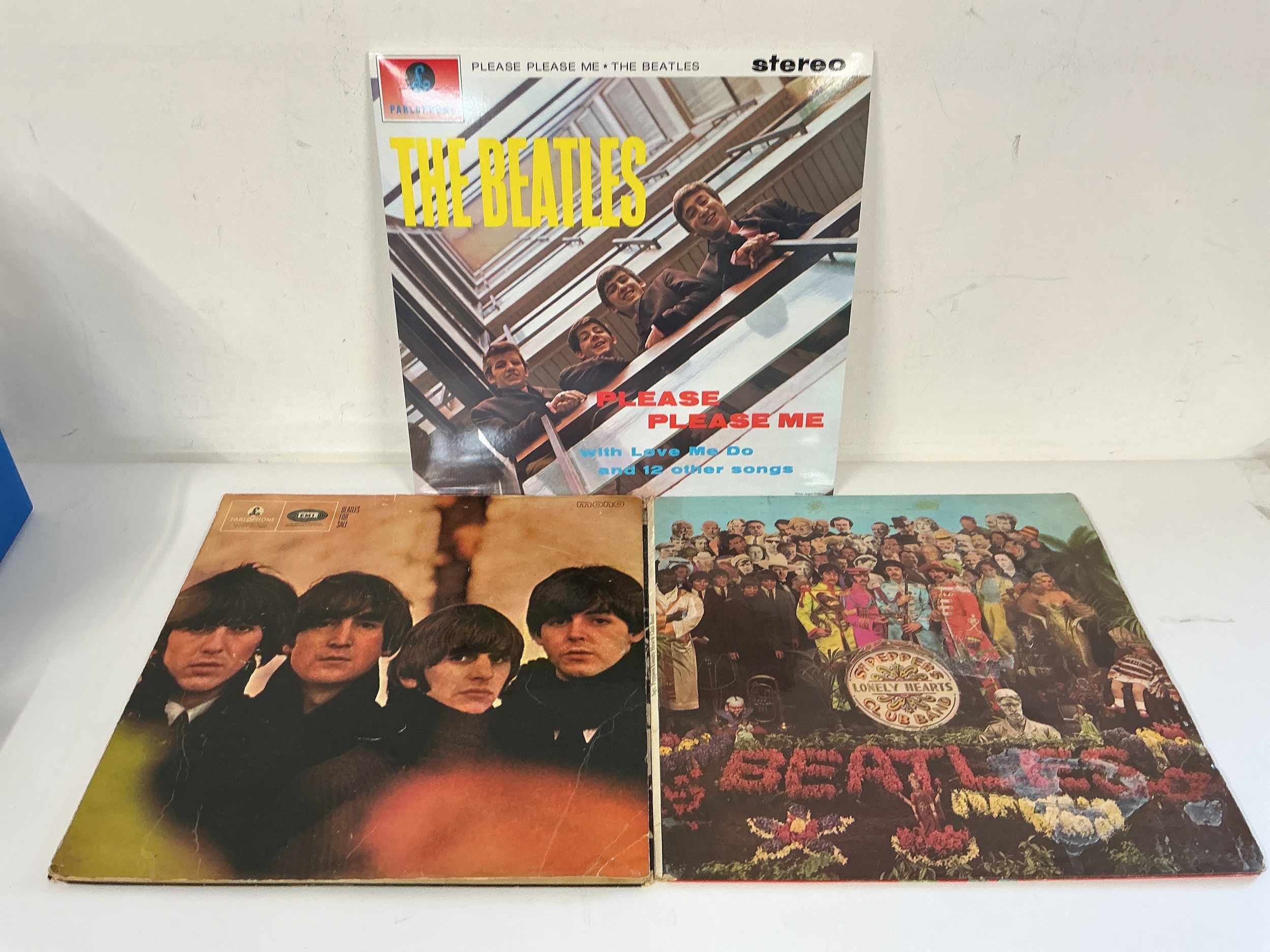 Three Beatles LPs comprising a NM 180g stereo pressing of Please Please Me plus two early pressings of Beatles For Sale and Sgt Pepper's, both of these have feelable scratches.