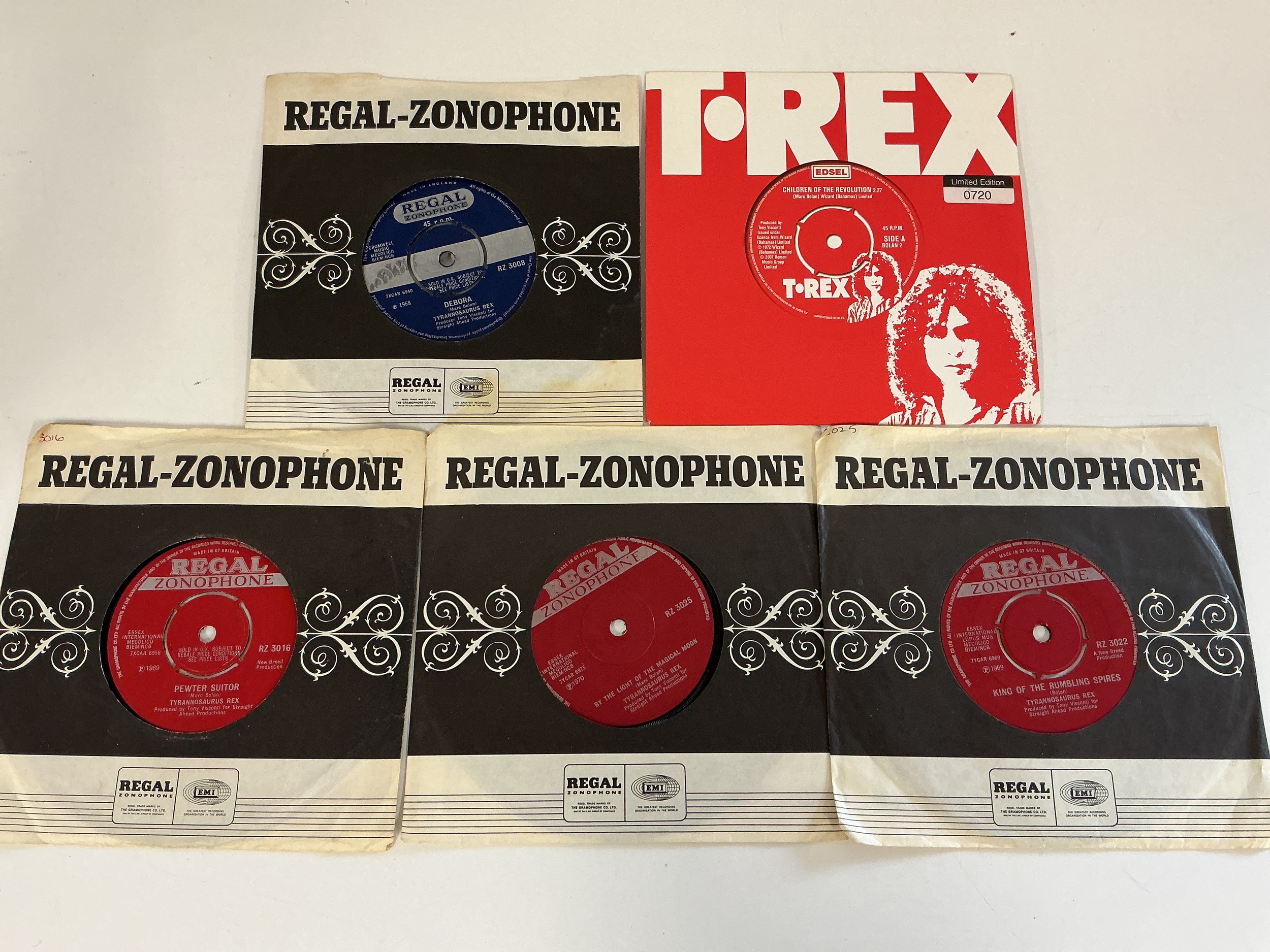 Five T Rex / Tyrannosaurus Rex 7" singles including early releases on the Regal Zonophone label. Pewter Suitor RZ 3016, King Of The Rumbling Spires RZ 3022, By The Light Of The Magical Moon RZ 3025, Debora RZ 3008 and a red vinyl pressing of Children Of The Revolution Bolan 2.