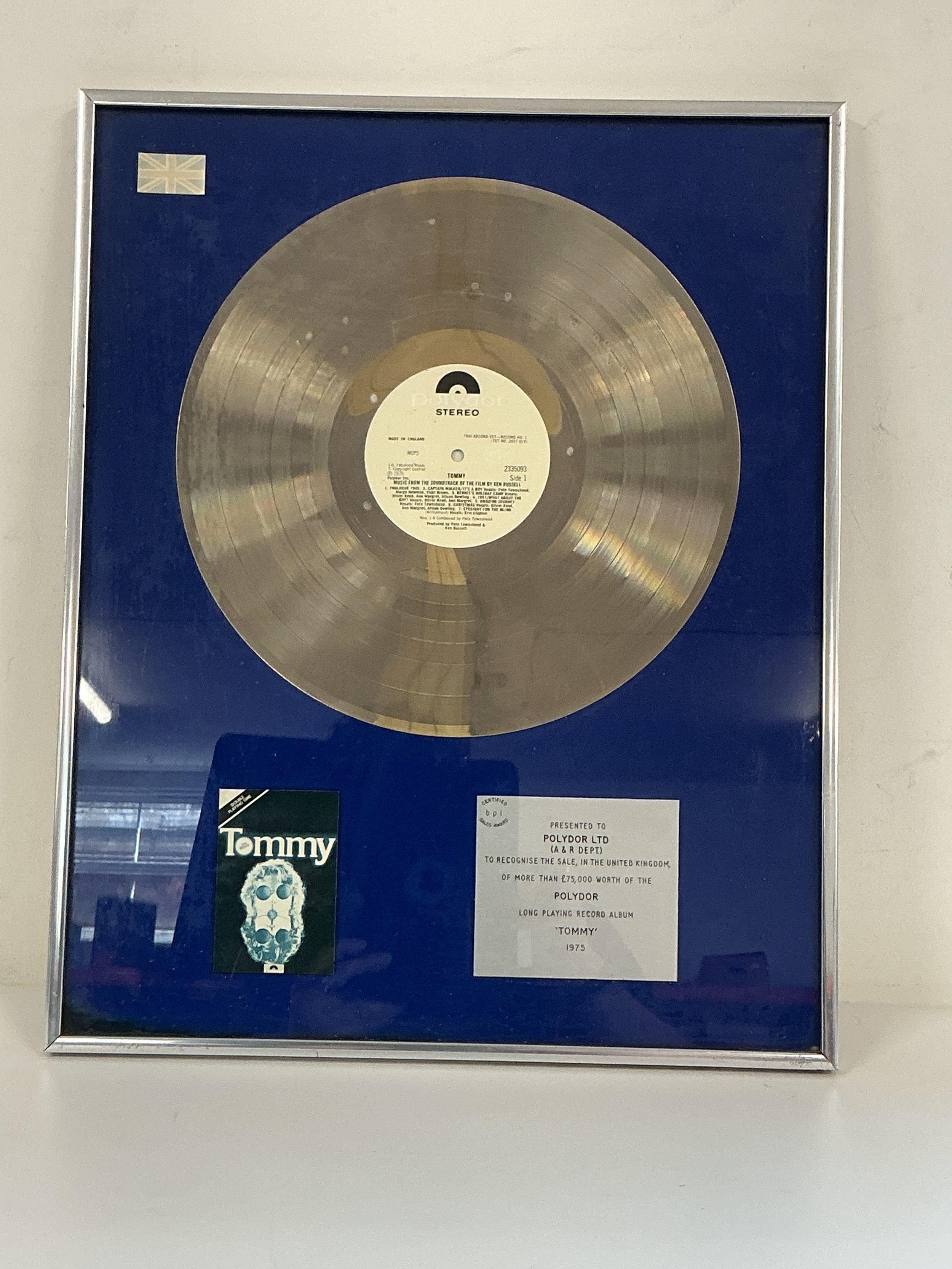 A framed and glazed silver disc presented to Polydor Records A&R department in recognition of £75,000 worth of sales of the Tommy Soundtrack LP by The Who, approx 41.5cm x 51.5cm.