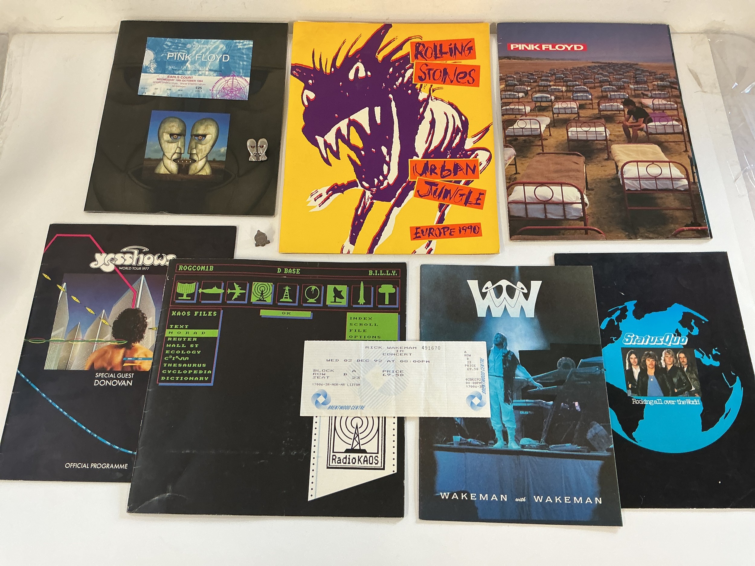 A collection of music programs, some with tickets for various artists including Pink Floyd, Rolling Stones, Yes and others. Includes two metal pin badges.