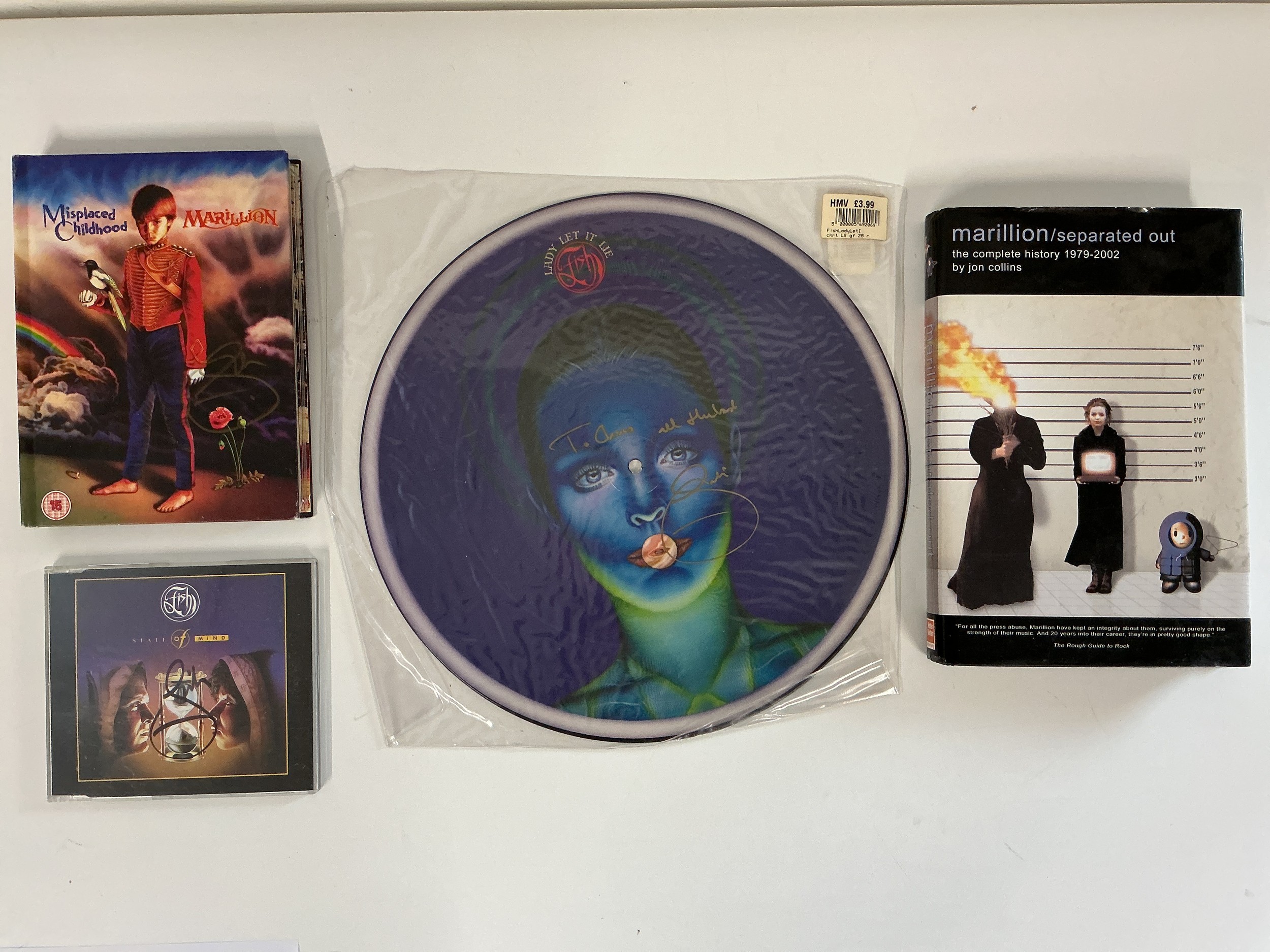 Marillion interest. Four signed items comprising a CD/DVD box set, book, a Fish 12" picture disc and a CD (4).